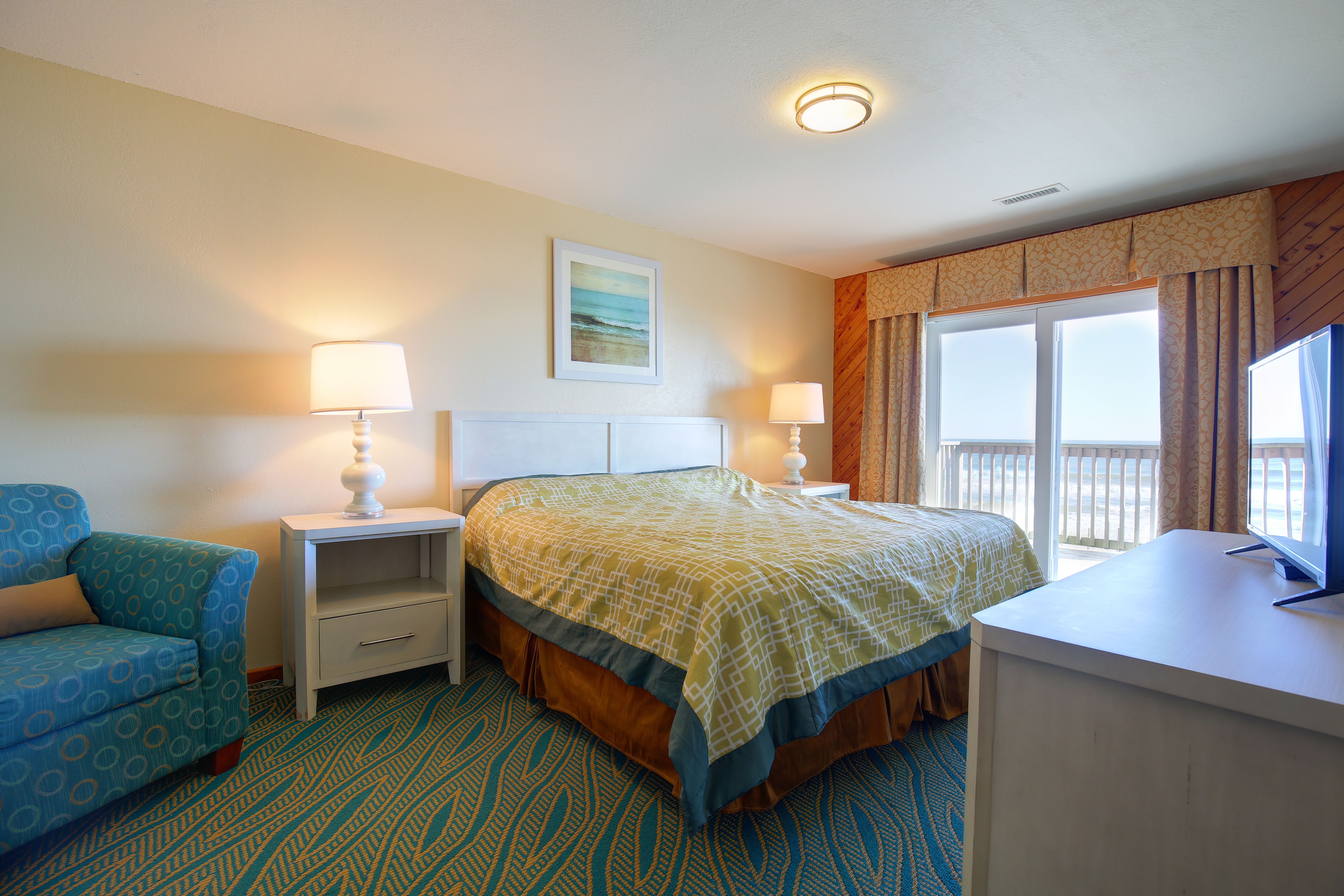image The comfortable master bedroom provides a cozy retreat with stunning coastal views accessible directly from the room.