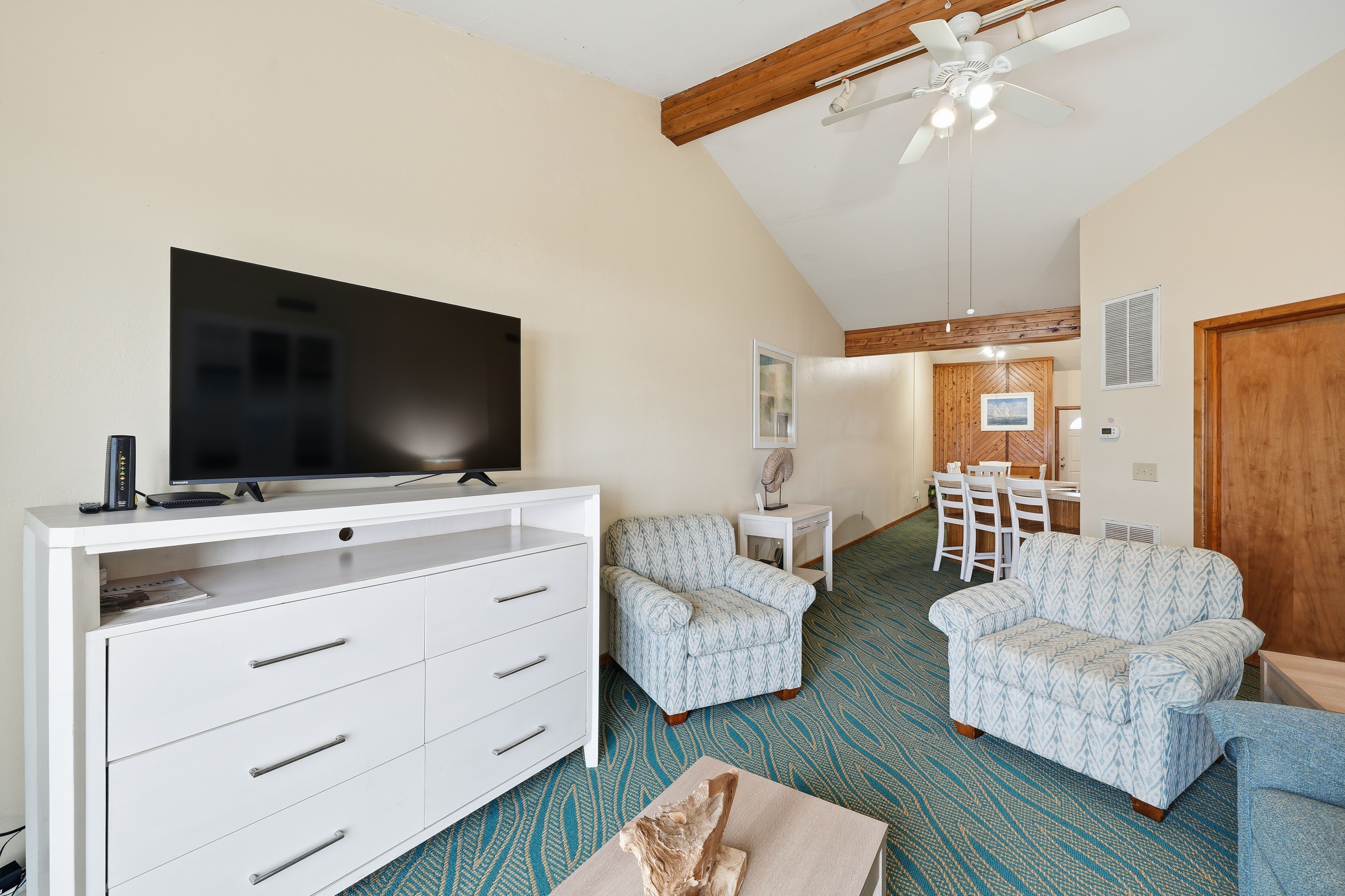 image Cozy up in the bright living area, featuring chic seating and a flat-screen TV for movie nights with family and friends.