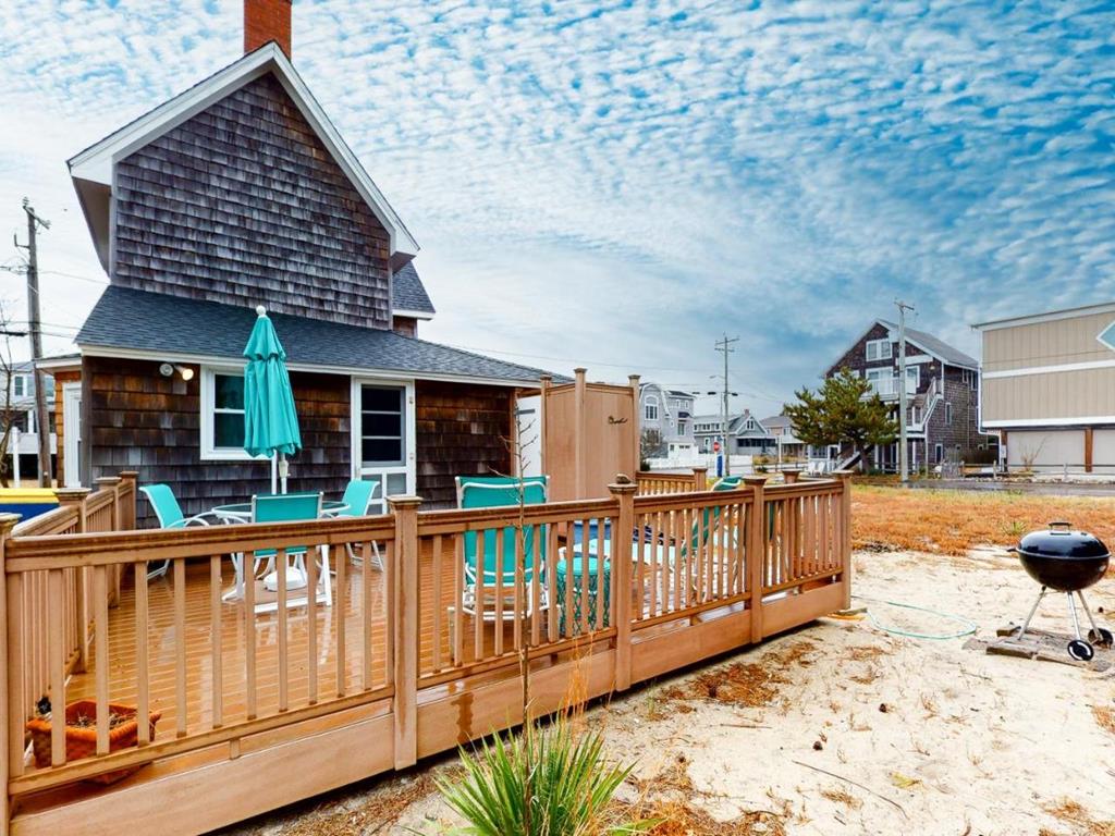 image The outdoor deck offers a relaxing space with turquoise seating, perfect for enjoying the beachside atmosphere amidst nearby homes and vegetation.