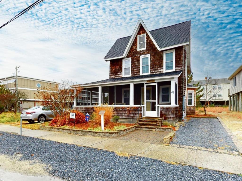 image This charming four-bedroom house features a traditional exterior with shingle siding and a welcoming porch, set on a spacious lot in Bethany Beach.