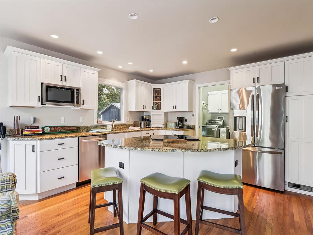image The modern kitchen, with its light-filled space and stylish cabinetry, offers a cozy gathering place for family meals and culinary creativity in a serene coastal setting.