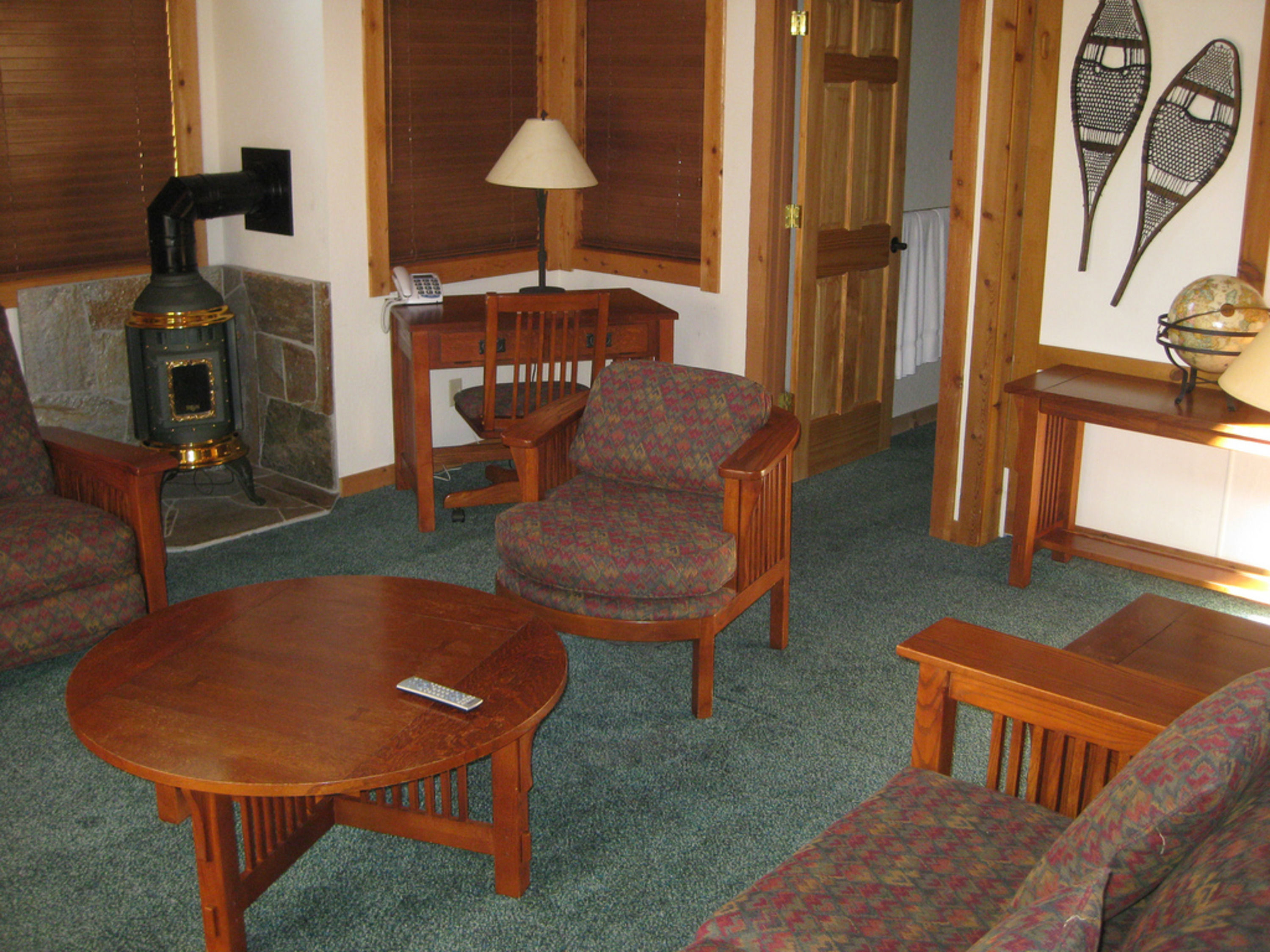 image Inside the 3BR home, the cozy living area showcases comfortable furniture and a stylish wood stove, creating a warm atmosphere ideal for relaxation.