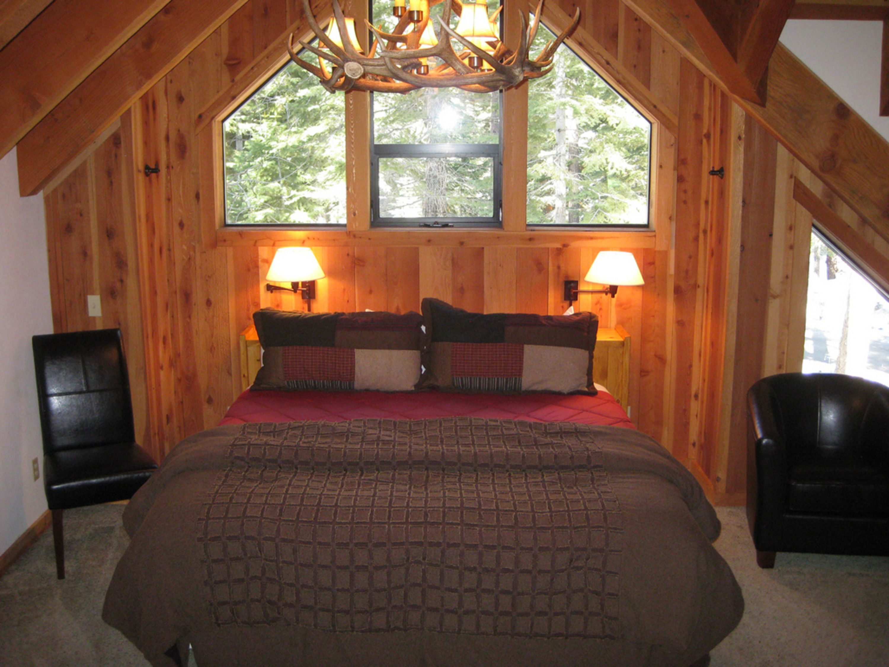 image The beautifully designed bedroom features cozy bedding and large windows that offer stunning views of the surrounding forests, ensuring a restful retreat.