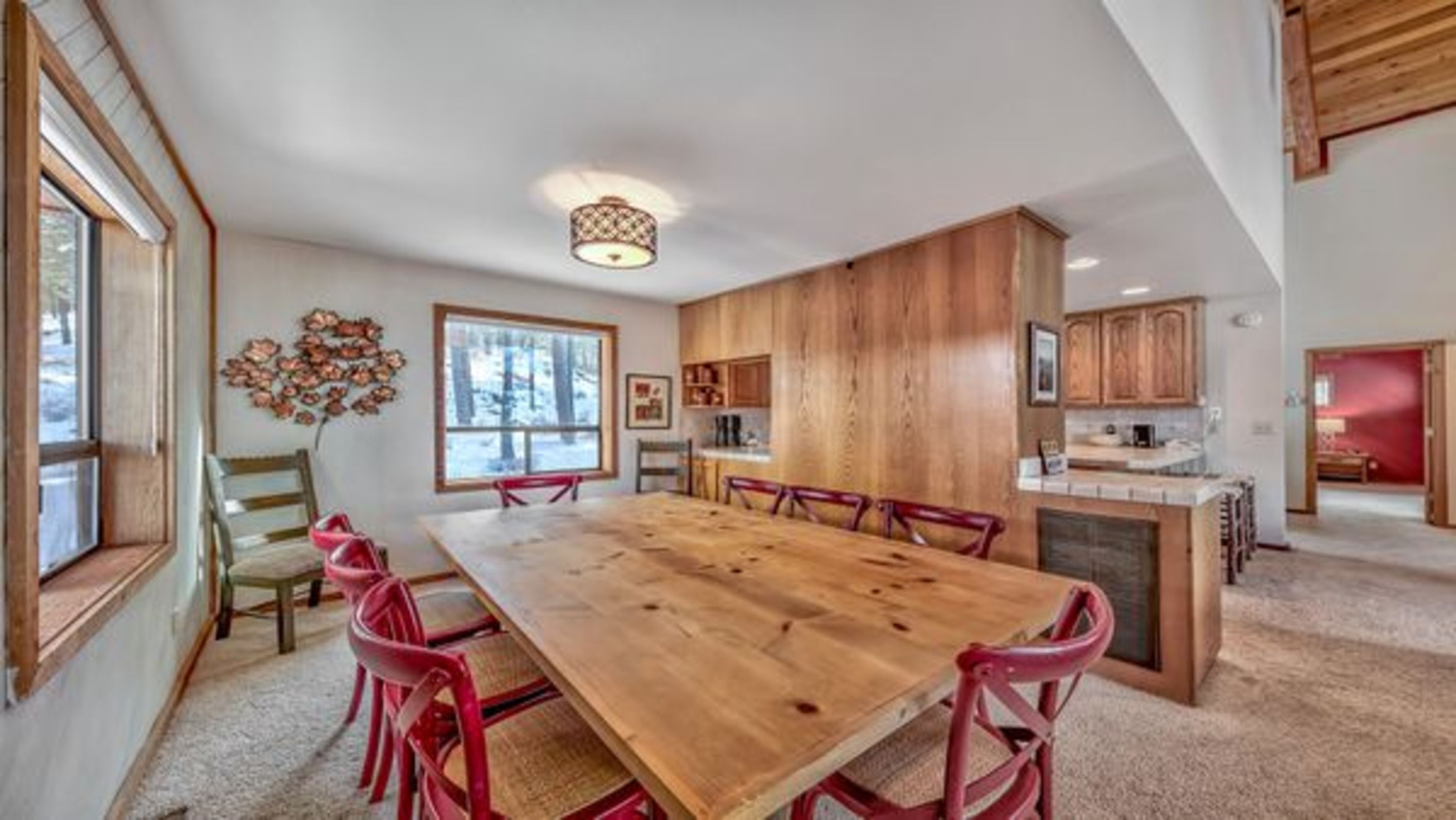 image The dining area features a rustic wooden table surrounded by vibrant red chairs, creating a cozy and inviting space perfect for family gatherings.