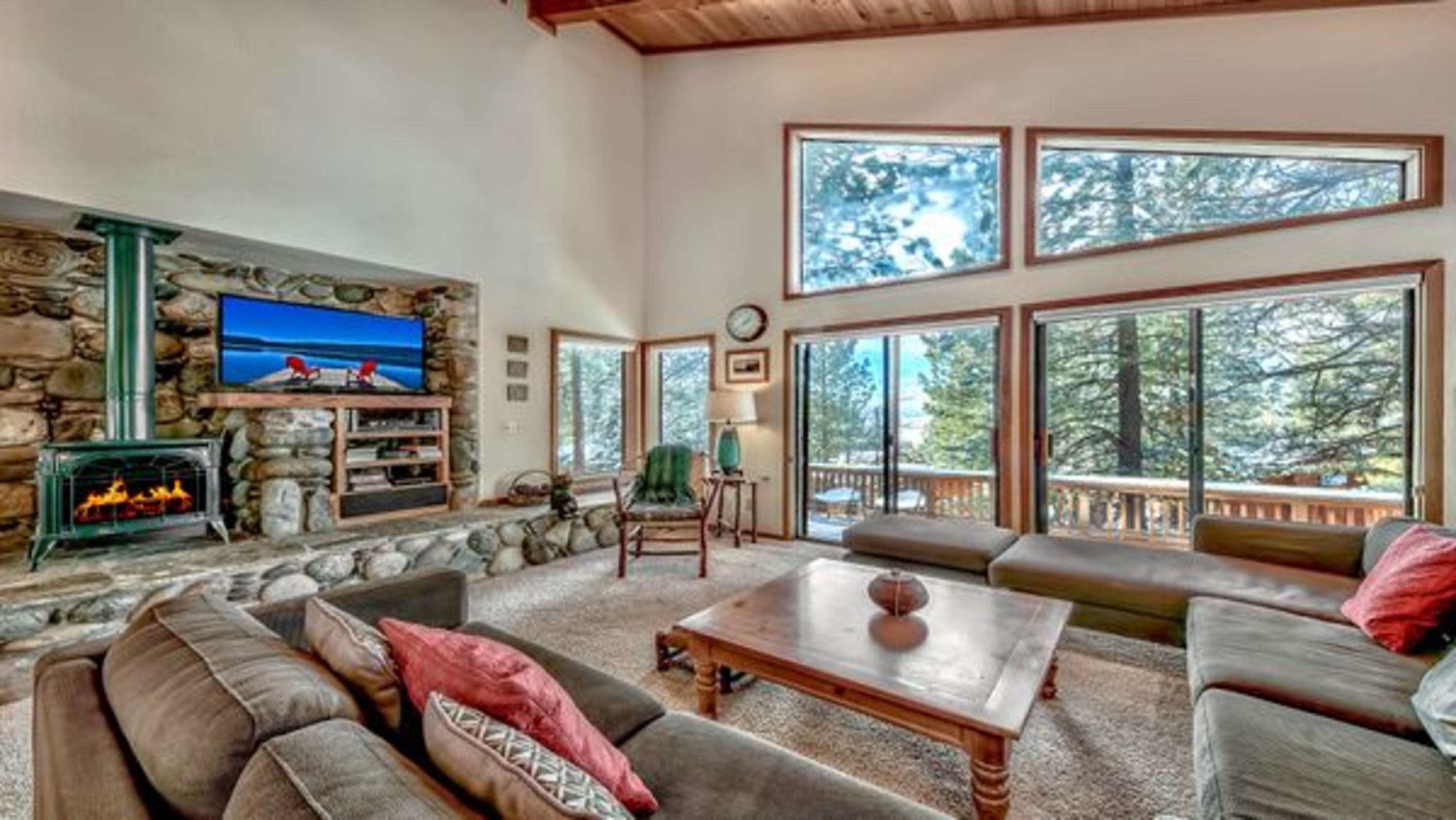 image The inviting living room boasts high ceilings, a stone fireplace, and expansive windows that frame breathtaking mountain views, creating a perfect gathering space.
