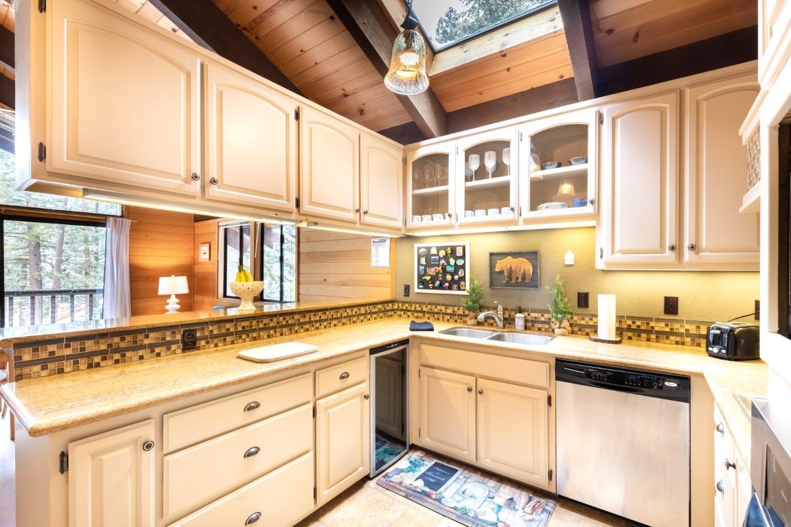 image Modern kitchen featuring light cabinets, sleek countertops, and ample natural light from skylights.