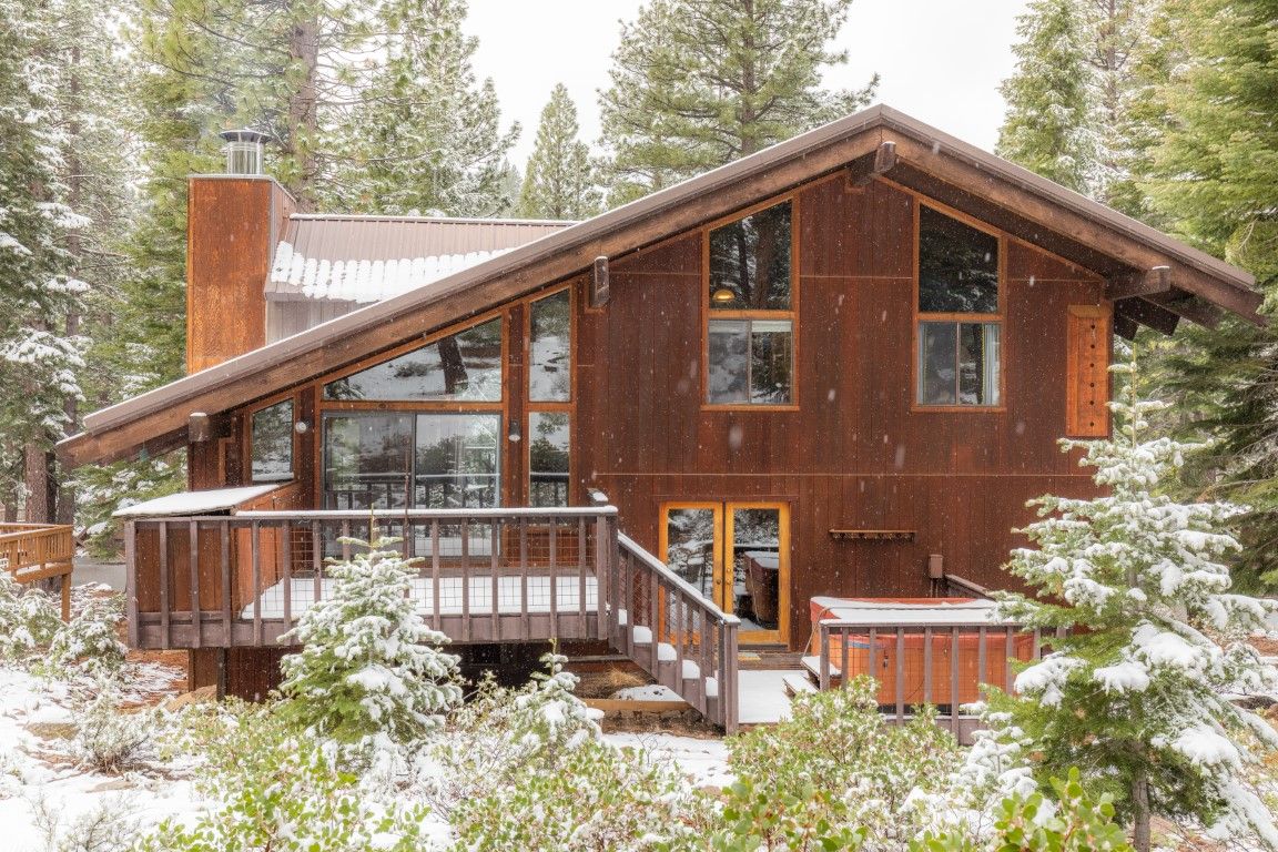 image Exterior view of the Northstar home showcasing its wooden architecture and spacious deck surrounded by snow-laden trees.