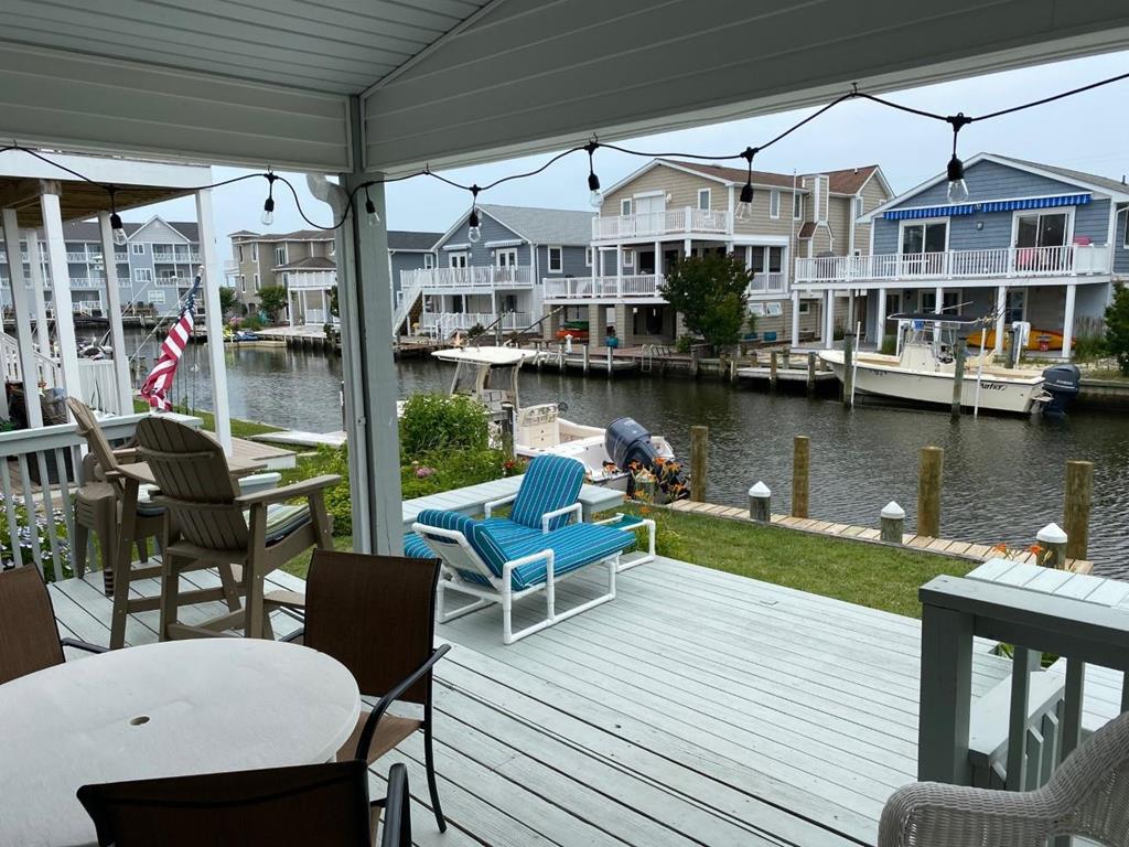 image Covered waterfront deck with lounge seating, offering shade and peaceful canal views.