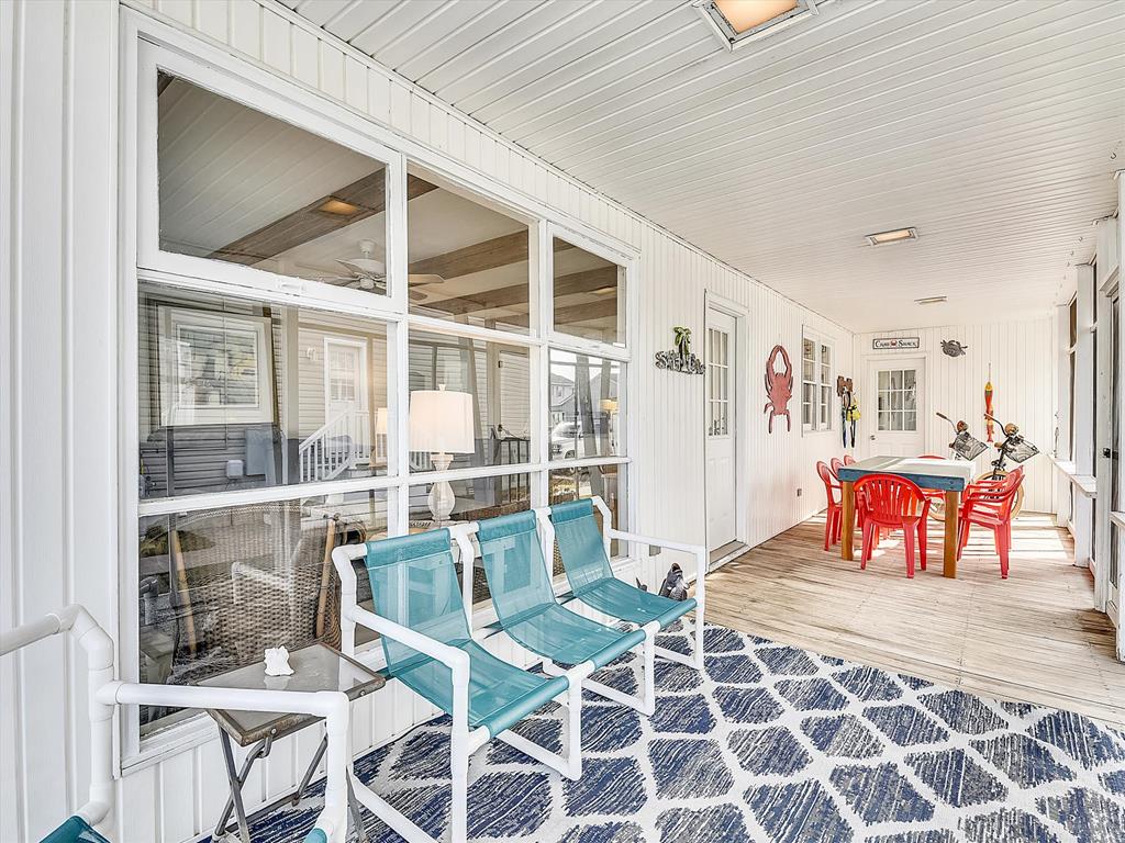 image This cozy screened-in seating area features playful coastal decor and inviting furniture, making it a great spot to relax with family and friends.