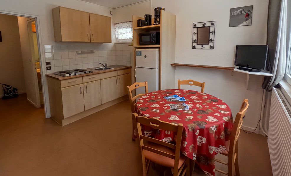 image The cozy kitchenette features a red tablecloth and a well-equipped space for meal preparation, bringing a warm atmosphere to the apartment.