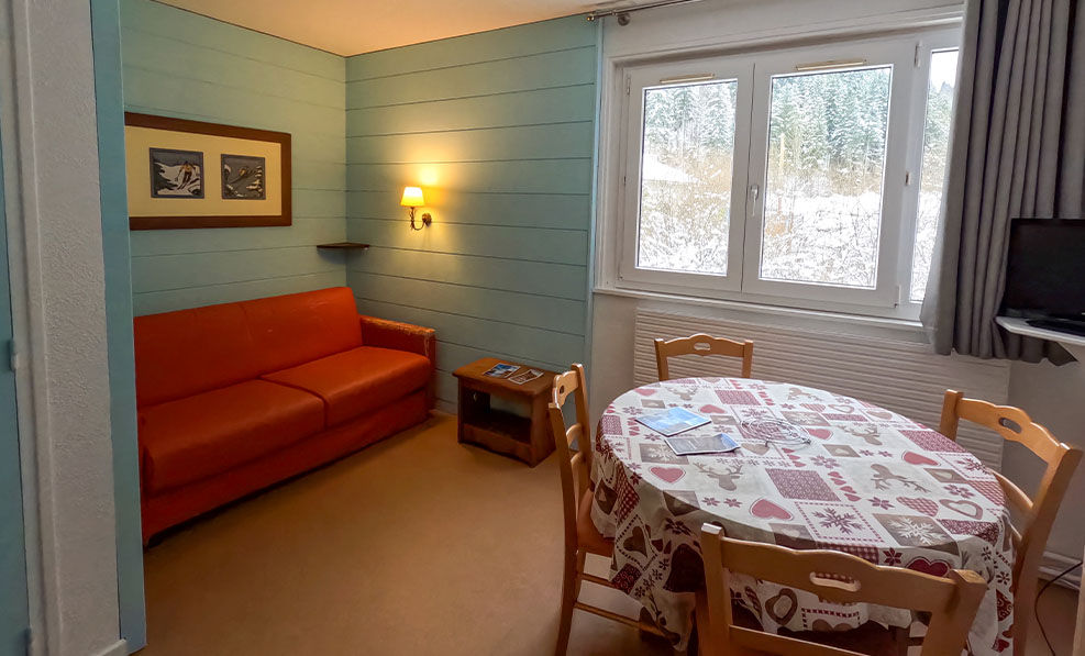 image A vibrant orange sofa contrasts the soft blue walls, creating a cheerful and relaxing environment to unwind after a day of exploring.