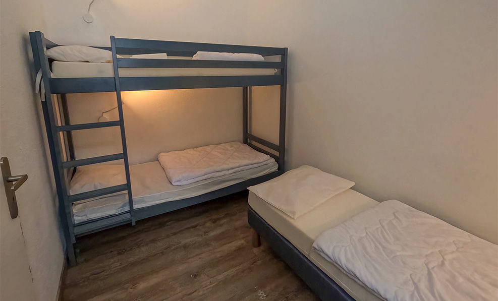 image Designed with family comfort in mind, the sleeping area features a sturdy bunk bed alongside a cozy single bed, ensuring a restful night's sleep after a day of mountain adventures.