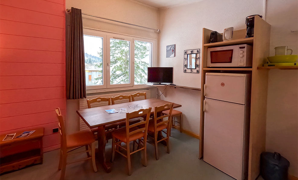 image With large windows framing stunning snow-covered views, this bright dining space offers a charming retreat that embodies the Jura alpine atmosphere.