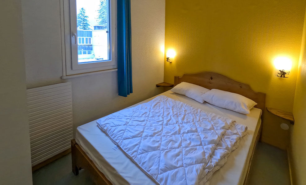 image The warm yellow hues of the bedroom create a peaceful retreat, perfect for restful nights after a day of exploring the beautiful Jura scenery.