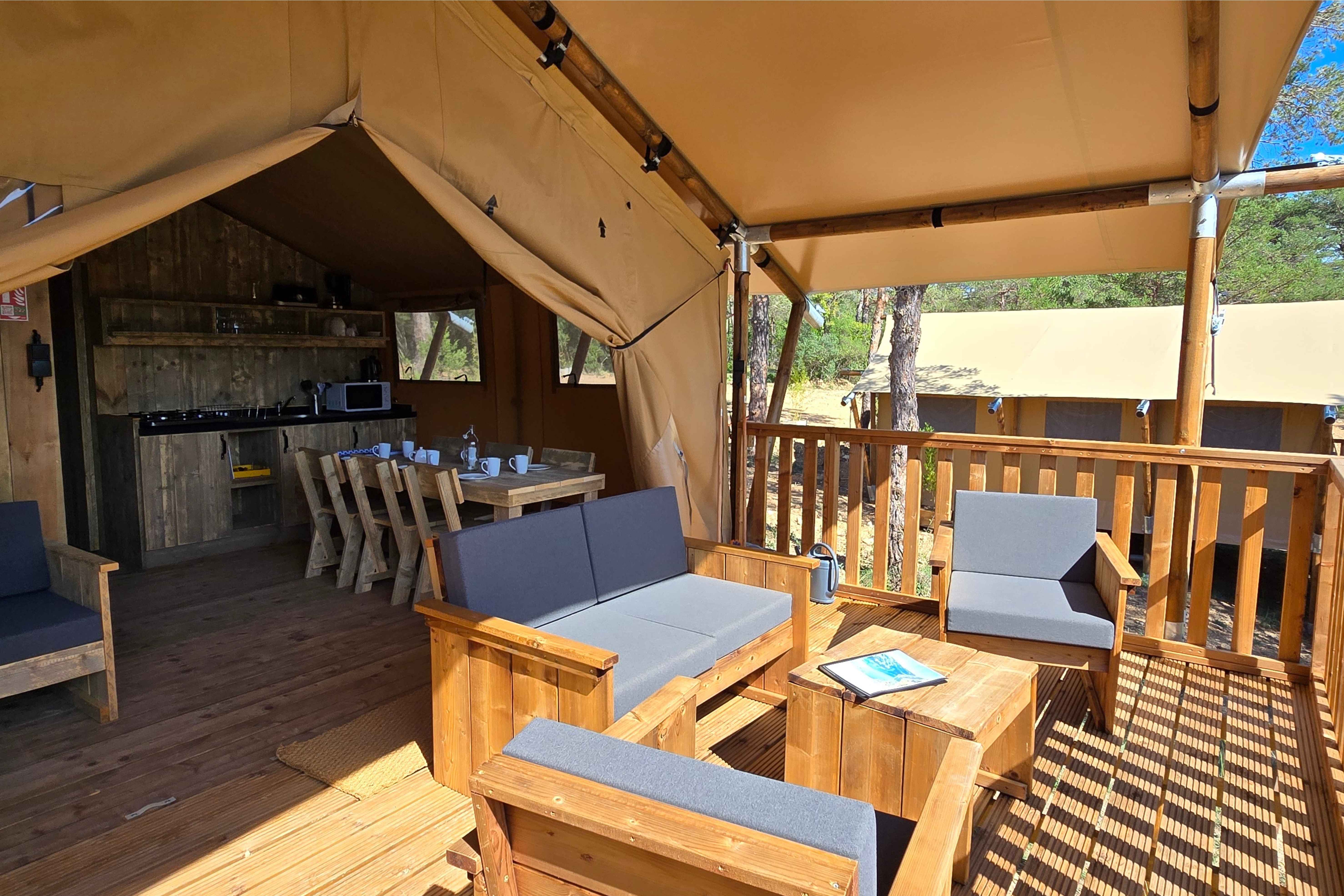 image Inside, the wooden terrace invites relaxation with comfortable seating and a cozy dining area, ideal for family meals.