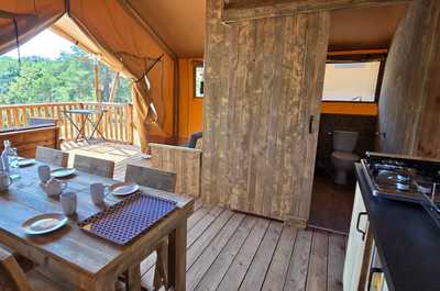 The interior showcases a rustic charm, complete with a dining table and modern kitchen amenities, ensuring a comfortable staying experience.