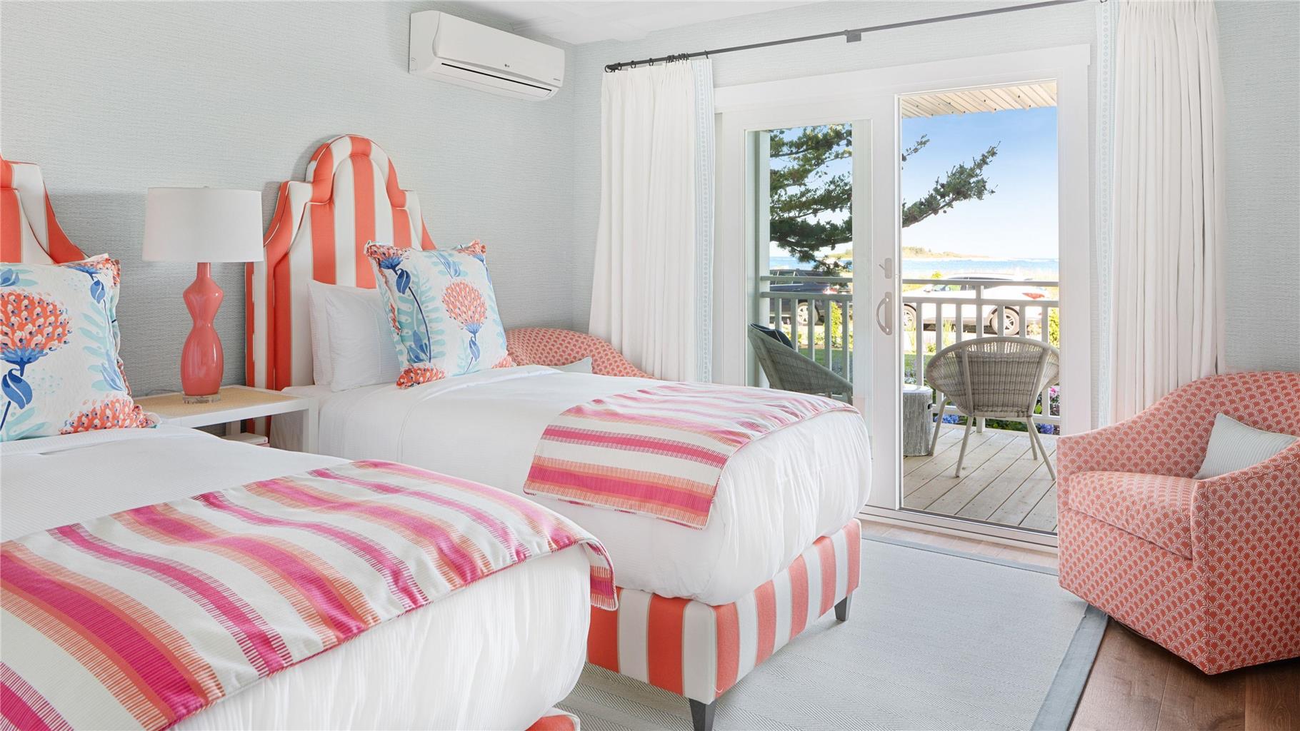 image A cheerful bedroom with striped beds and vibrant decor opens to a private balcony, allowing you to indulge in the refreshing coastal breeze.