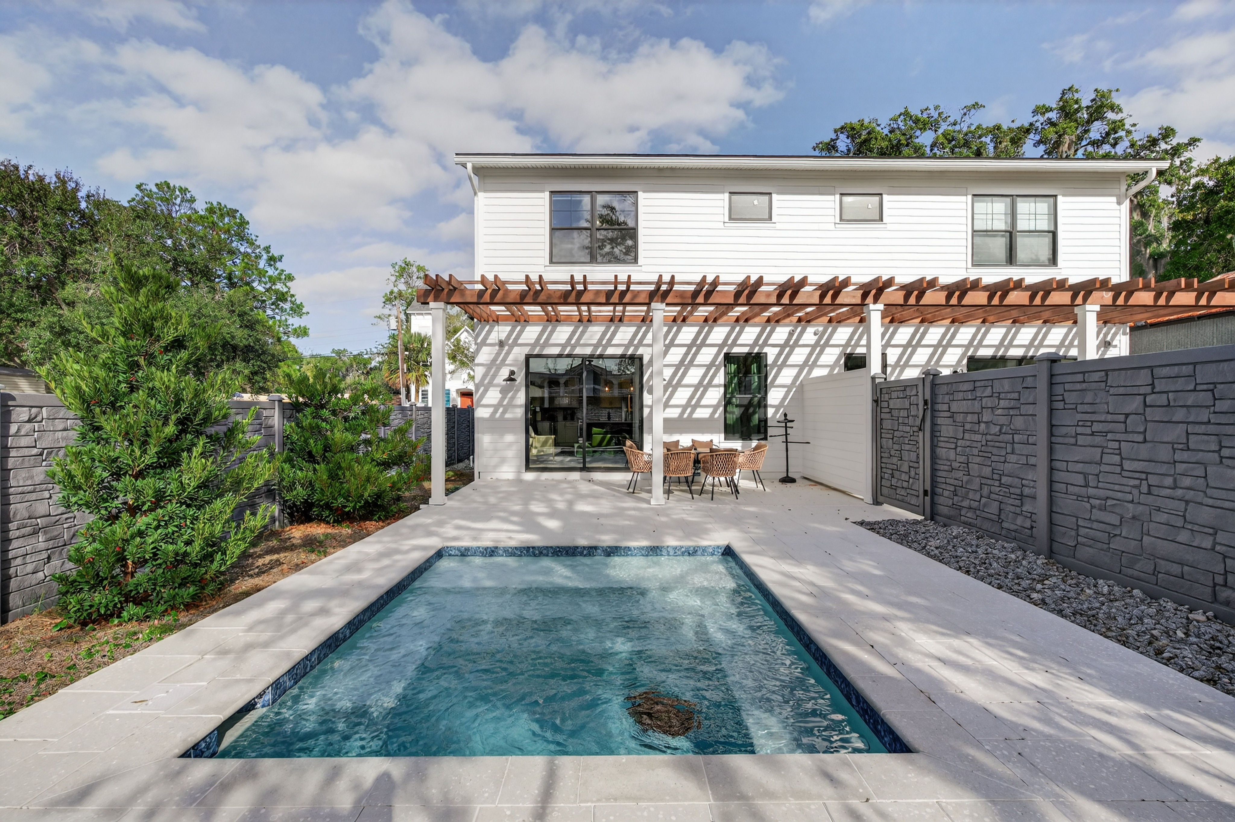 image The inviting exterior of the vacation home showcases a modern design with an adjacent pool, ideal for family gatherings.