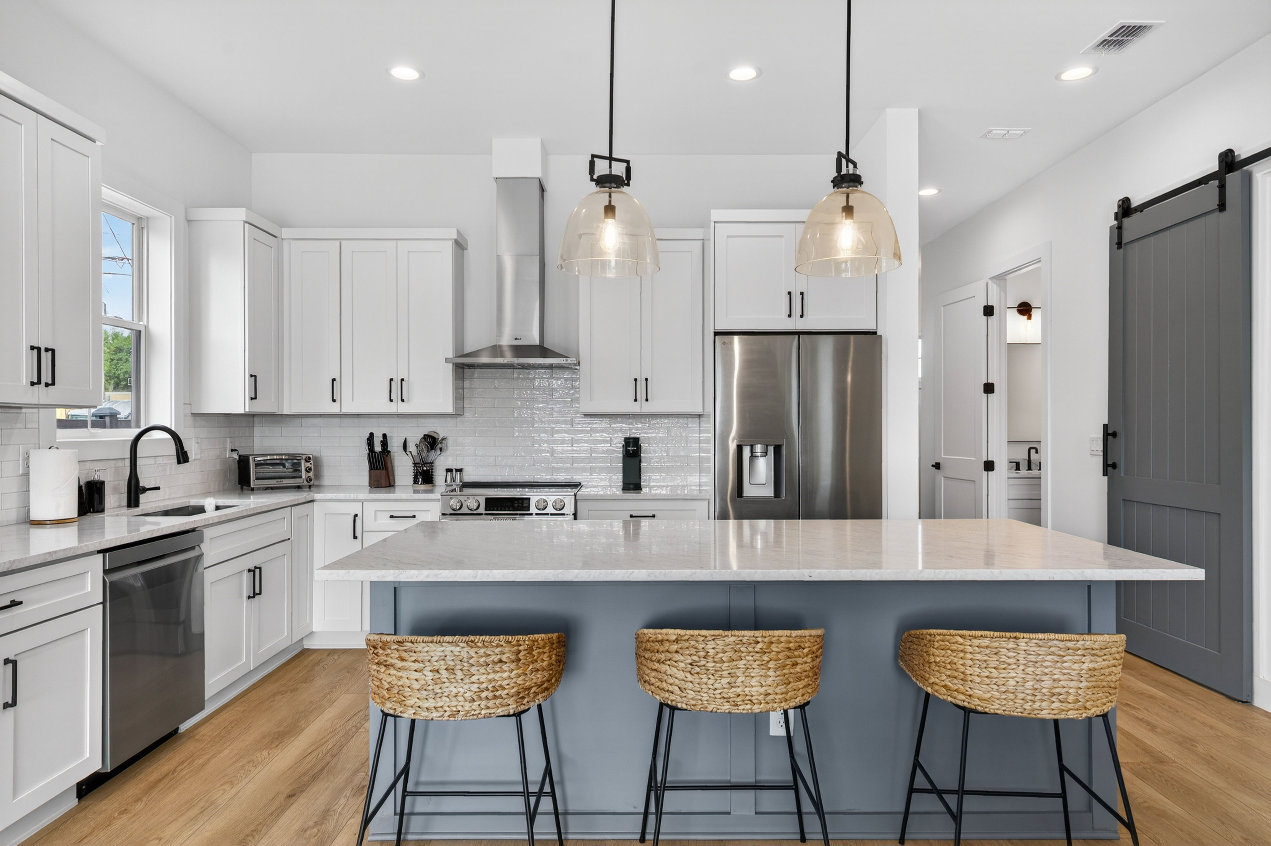 image A modern kitchen with sleek white cabinets and stylish pendant lighting creates an inviting culinary space.