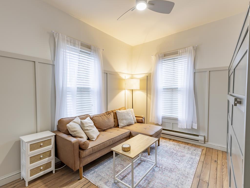 image Another view of the sunlit living room, offering comfort and flexibility for relaxation or sleeping.