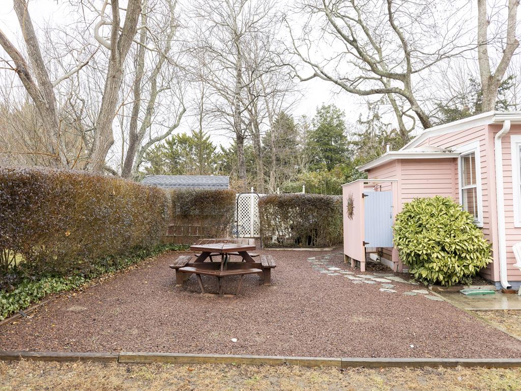 image Shared backyard space with picnic table, perfect for enjoying lunch outdoors or unwinding in nature.