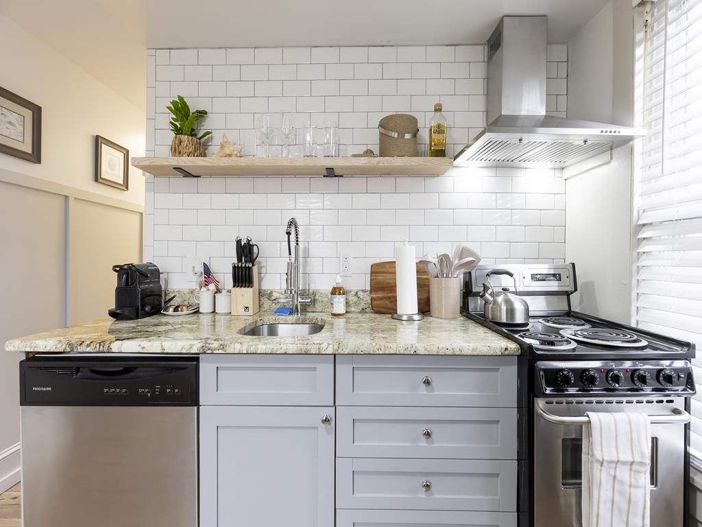 image Stylish kitchen features subway tile backsplash, open shelving, and modern finishes.