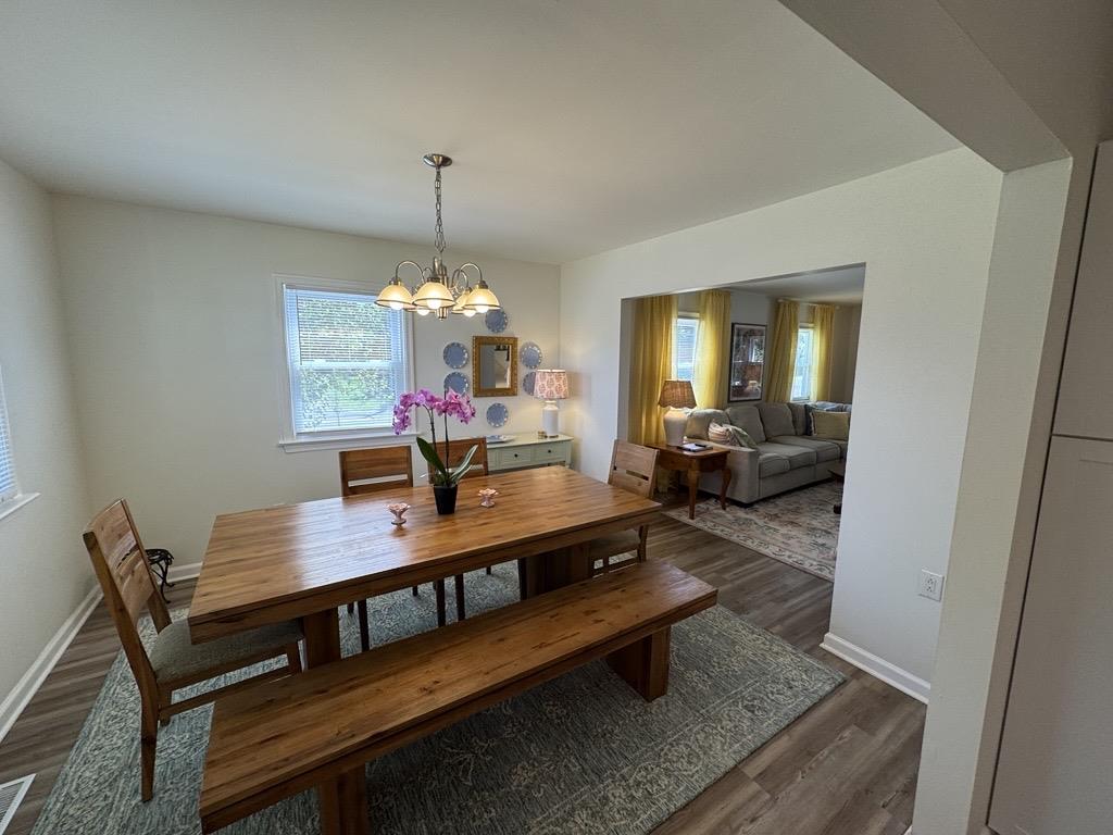 image A warm dining area with a rustic wooden table and soft chandelier glow.