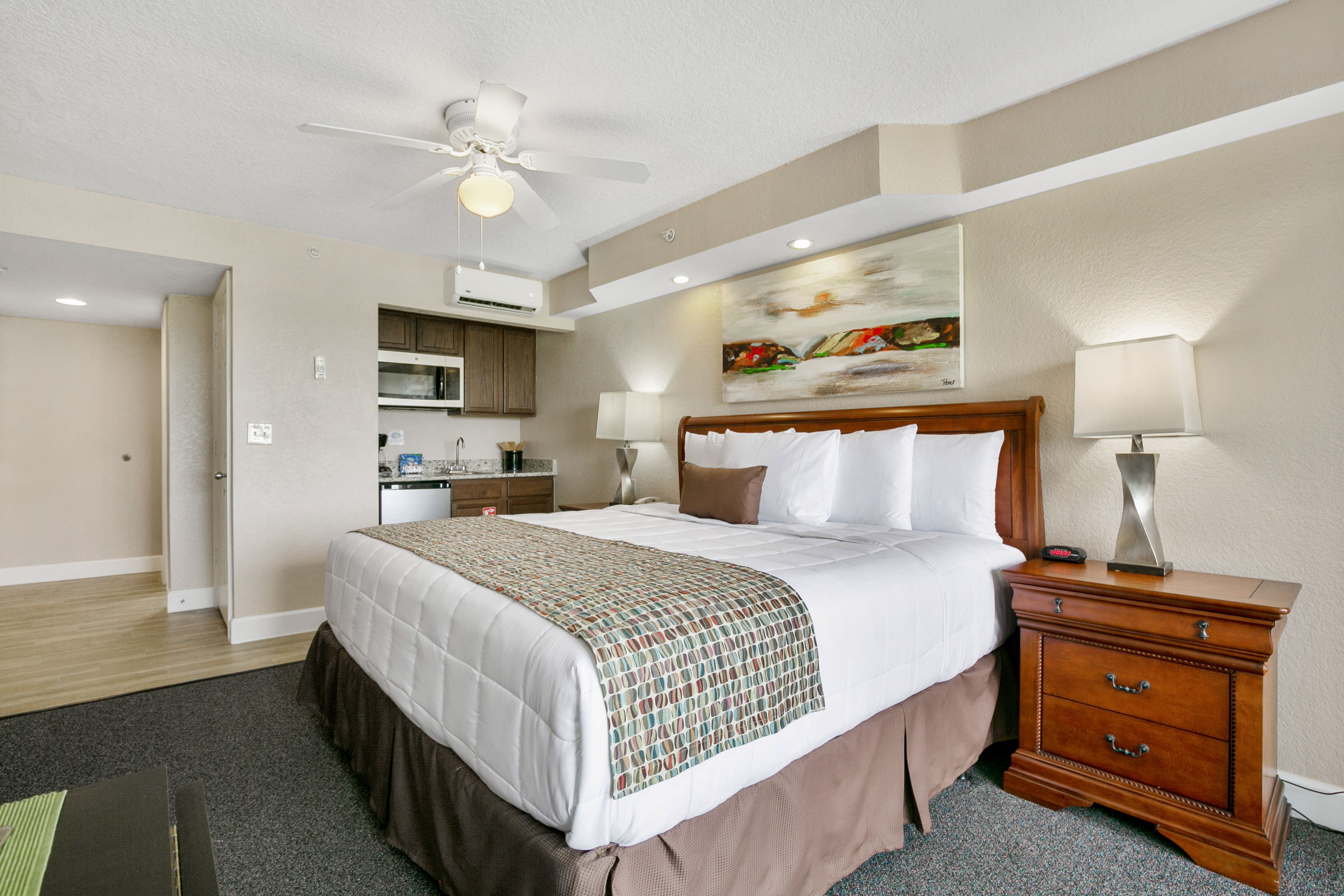 image Relax in a bright hotel room featuring a king bed, comfortable seating, and modern furnishings.