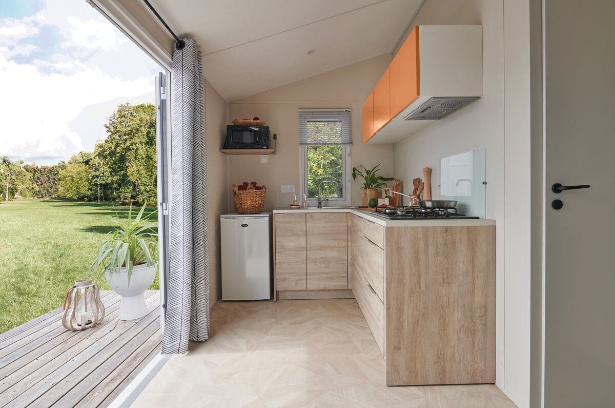 image The bright and airy kitchen boasts contemporary cabinetry, modern appliances, and large windows that connect with nature.