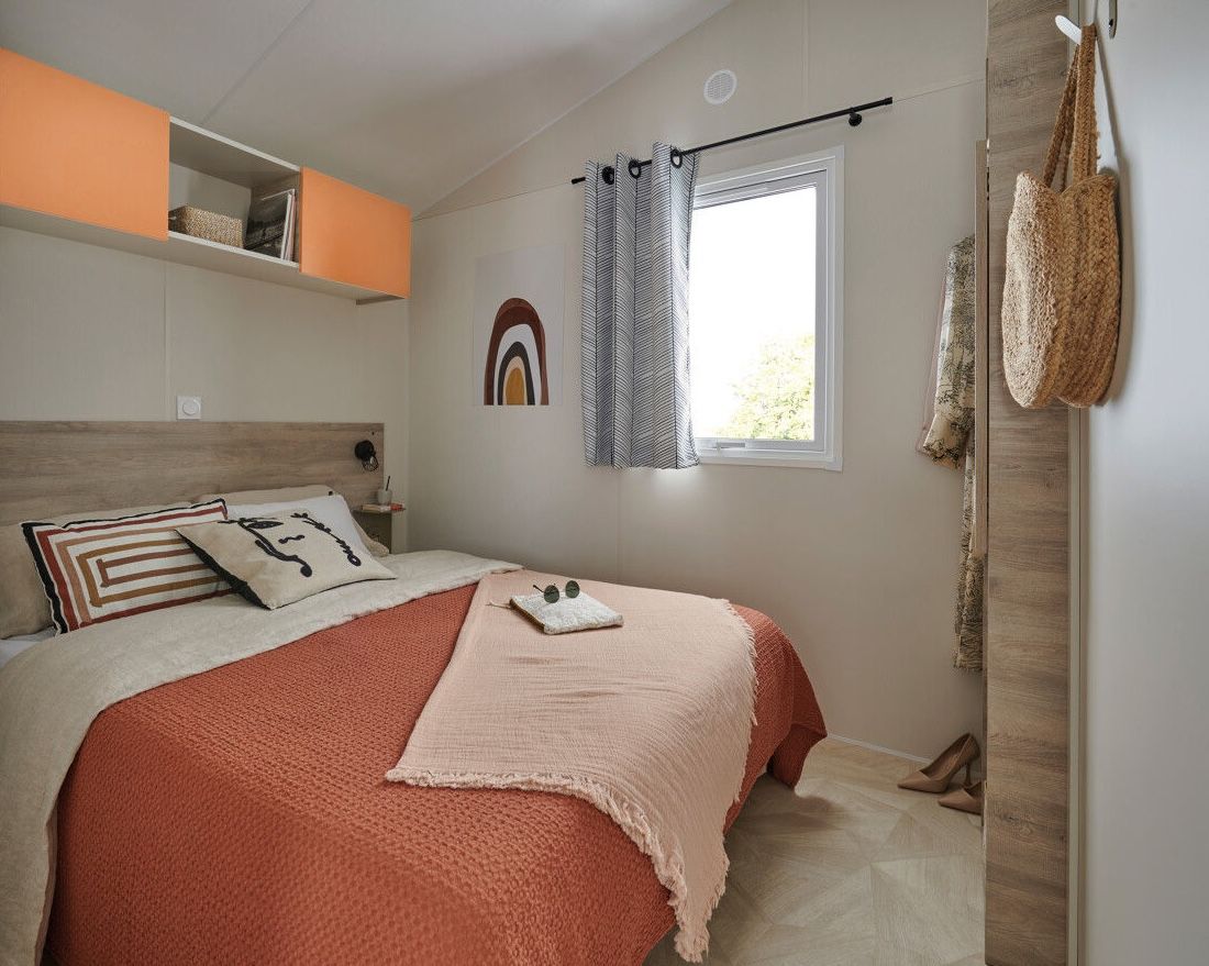 image The tranquil master bedroom features warm tones, thoughtfully arranged decor, and a window that frames scenic outdoor views.