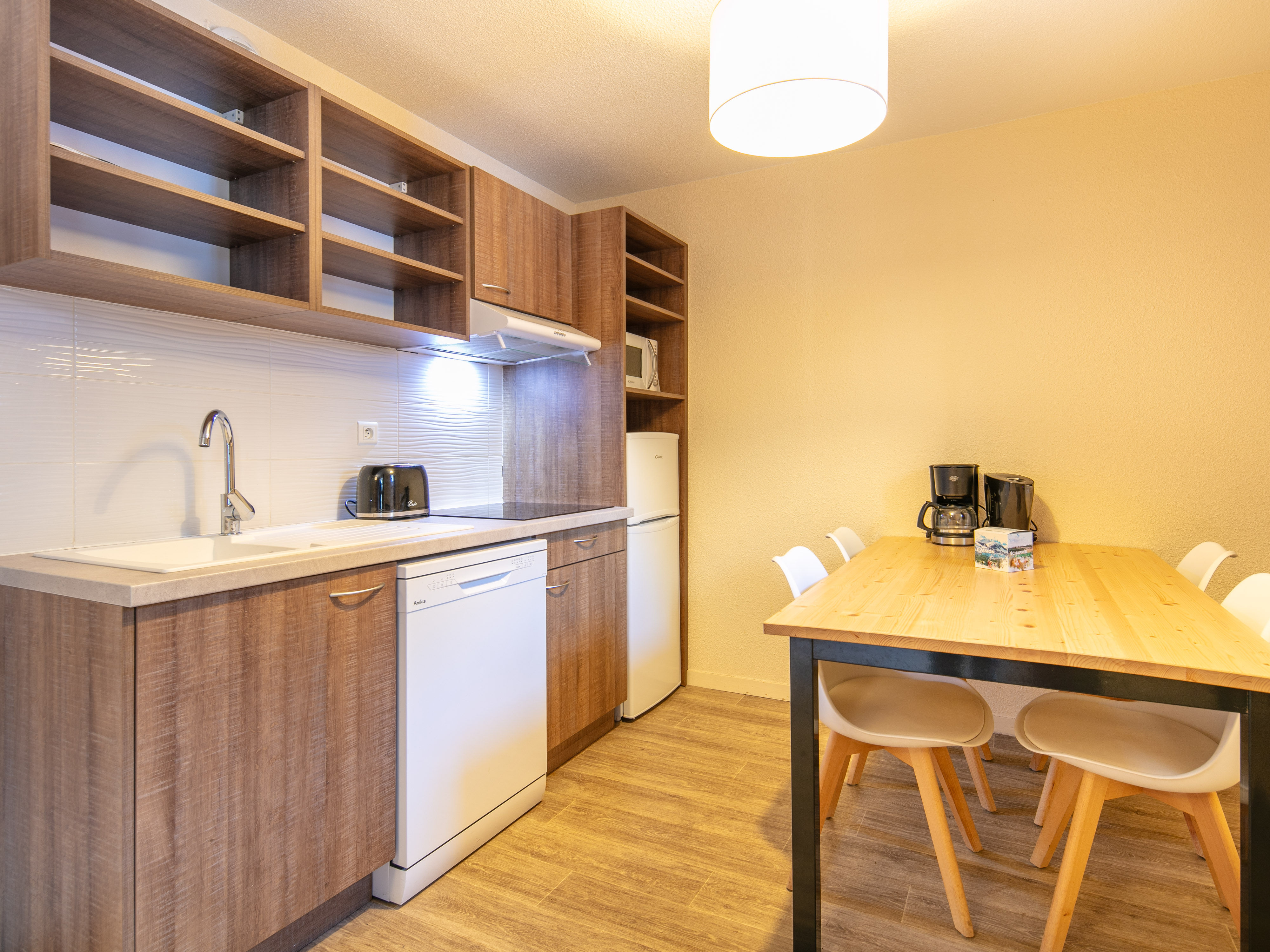 image This modern kitchen features sleek wooden cabinetry and a spacious dining area, perfect for family meals after a day of alpine adventures.