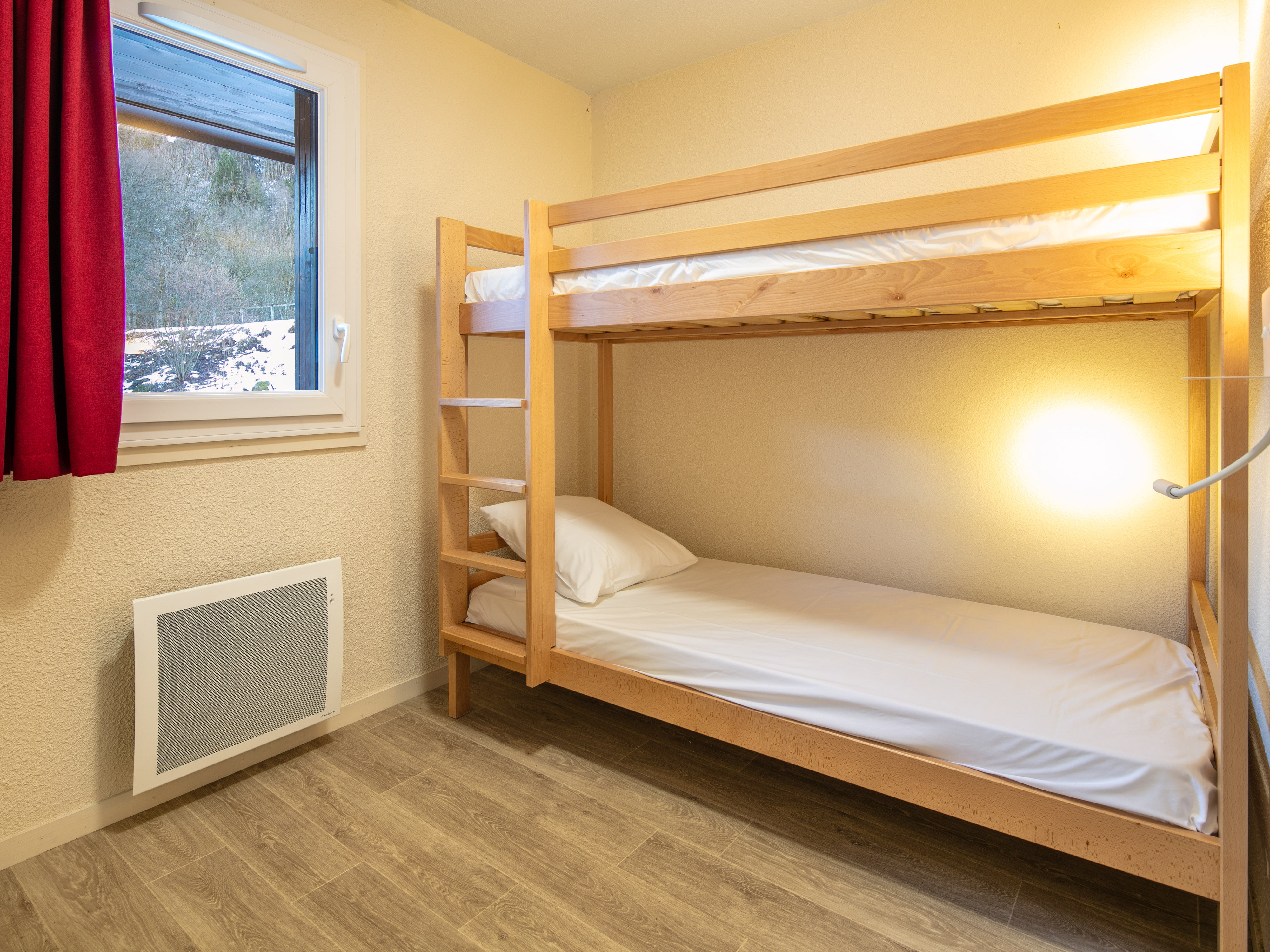 image This inviting bunk bedroom creates a cozy retreat, ideal for kids or extra guests, immersed in the warmth of the alpine style.