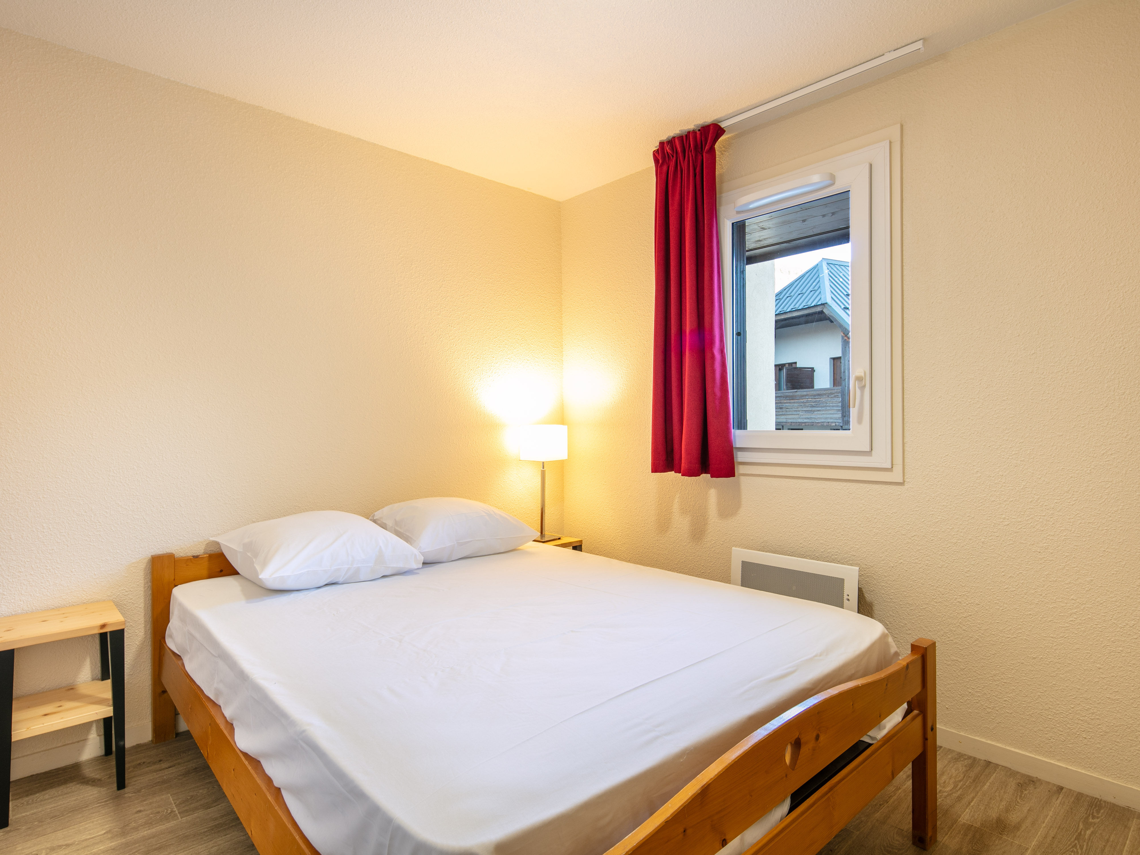 image A peaceful bedroom designed with warm wood elements, featuring comfortable bedding and natural light that enhances the alpine charm.