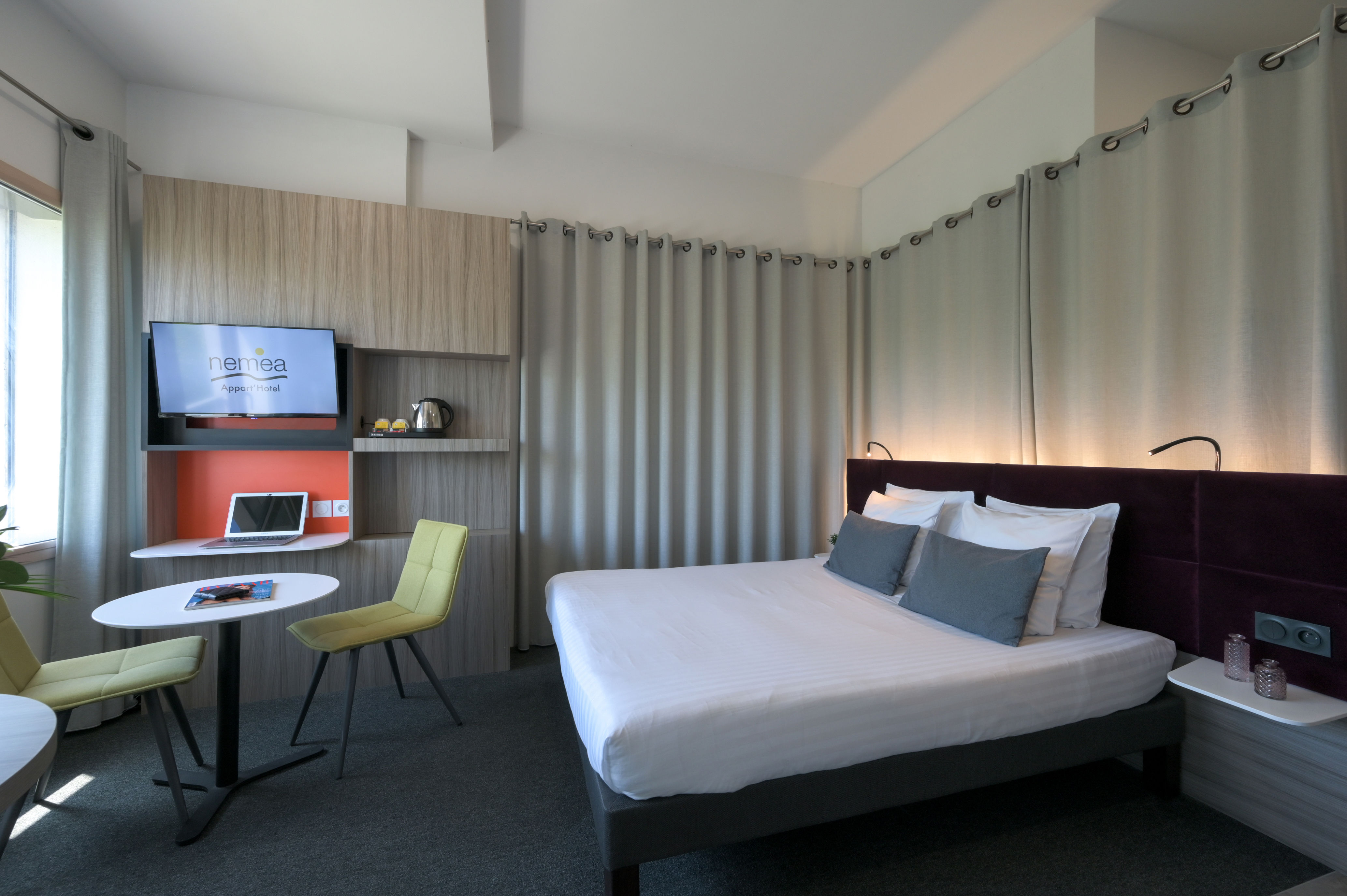 image Well-designed double room featuring a cozy sleeping area and a small seating space.