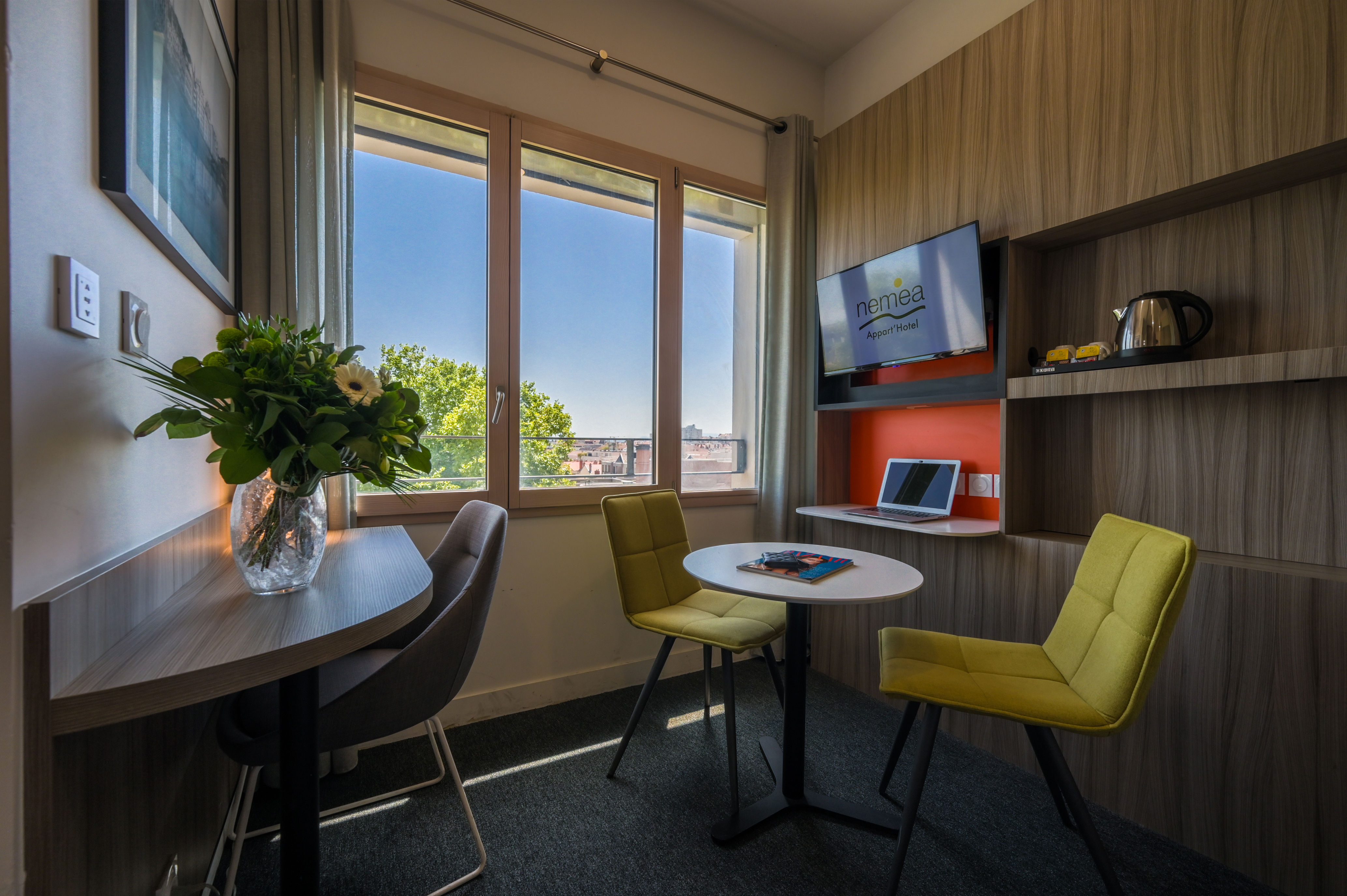 image Workspace and dining corner set by the window, ideal for business or leisure stays.