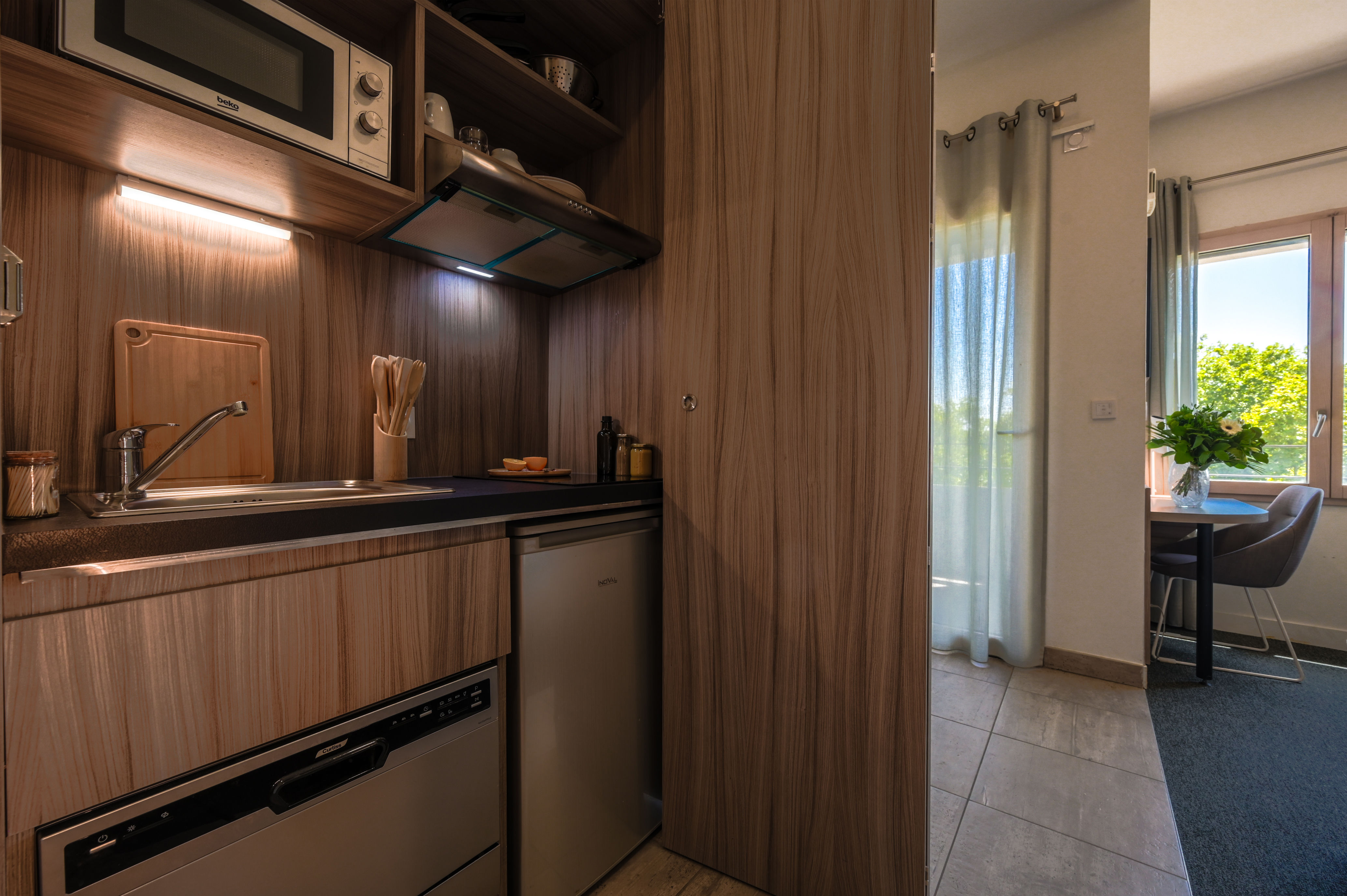 image Fully equipped kitchenette with cooking plates, microwave, refrigerator, kettle, and coffee maker.