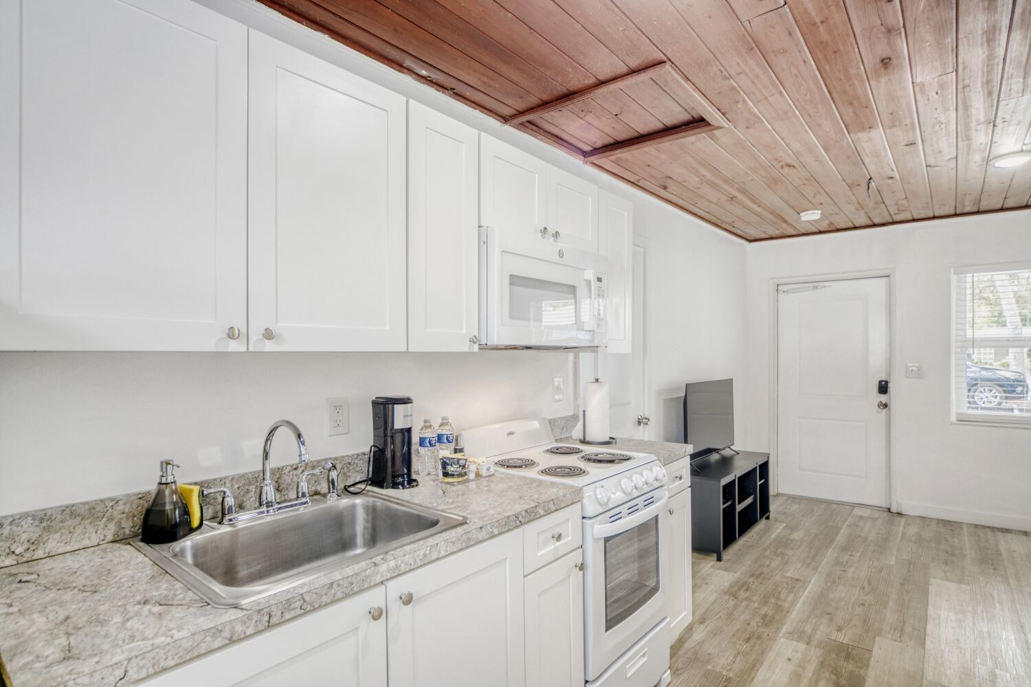 image Fully equipped kitchen offers modern appliances, granite countertops, microwave, coffee maker, and plenty of cabinet space for effortless meal prep.