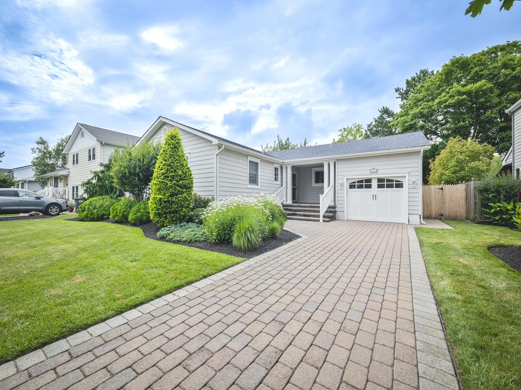 image Welcoming exterior of the home with a paved driveway, landscaped yard, and inviting front entrance.