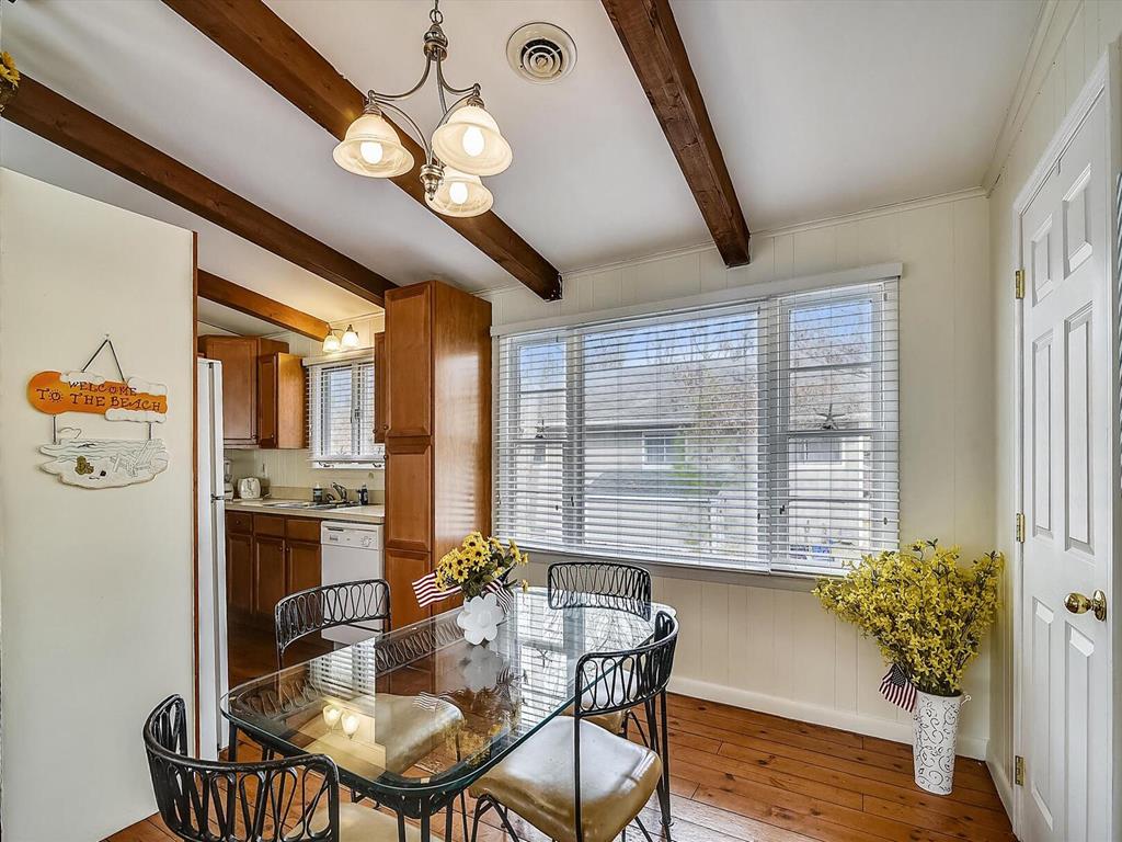 image This dining space seamlessly connects to the kitchen, adorned with beautiful wooden beams and a glass table perfect for breakfasts and evening meals.