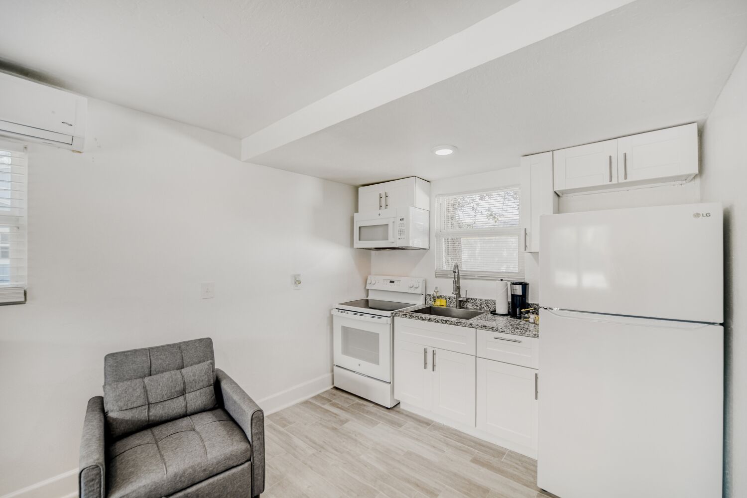 image Relaxing lounge space provides a comfy armchair and open views of the kitchen, ideal for unwinding with a book or streaming your favorite shows.