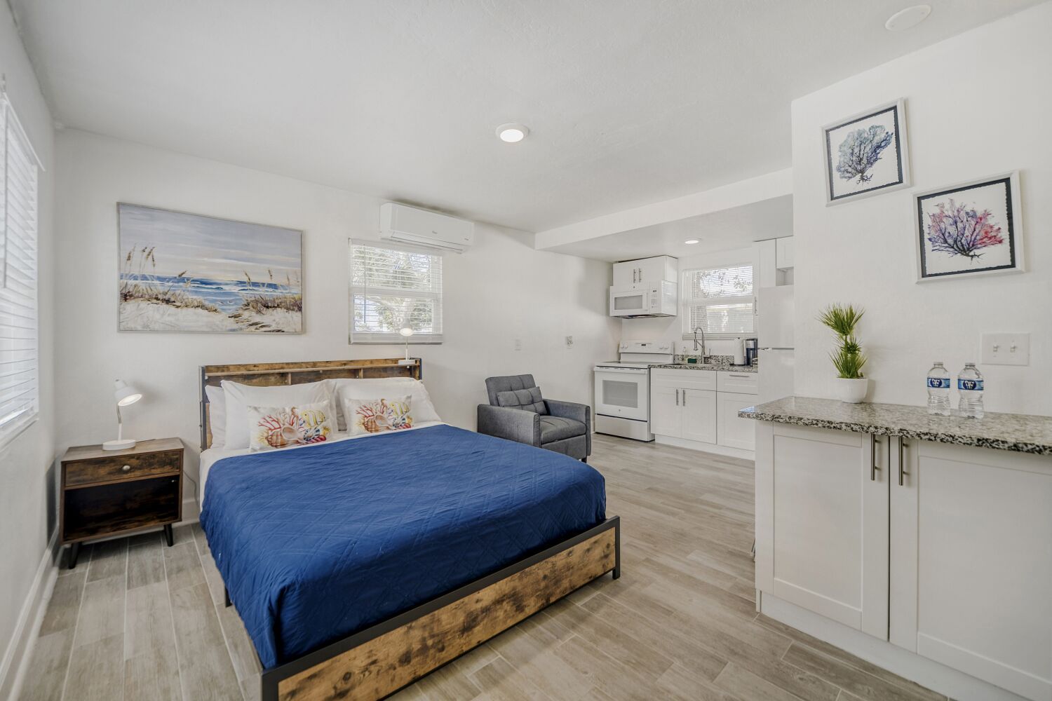 image Open-concept studio offers a plush bed, convenient kitchenette, and thoughtful décor, blending comfort with functionality for a restful stay.