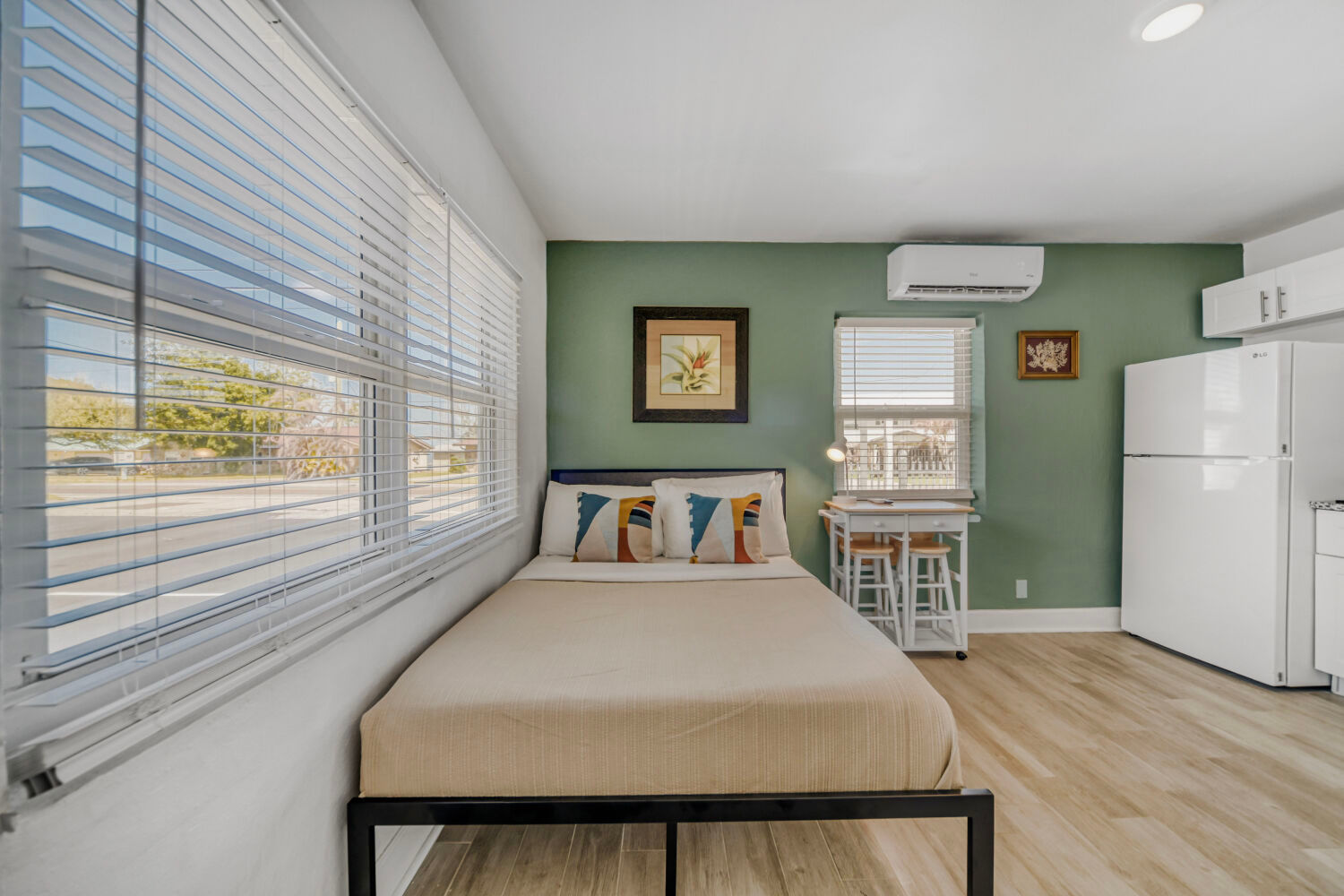 image Sleeping area with a full bed, TV, and simple furnishings in a bright studio layout.