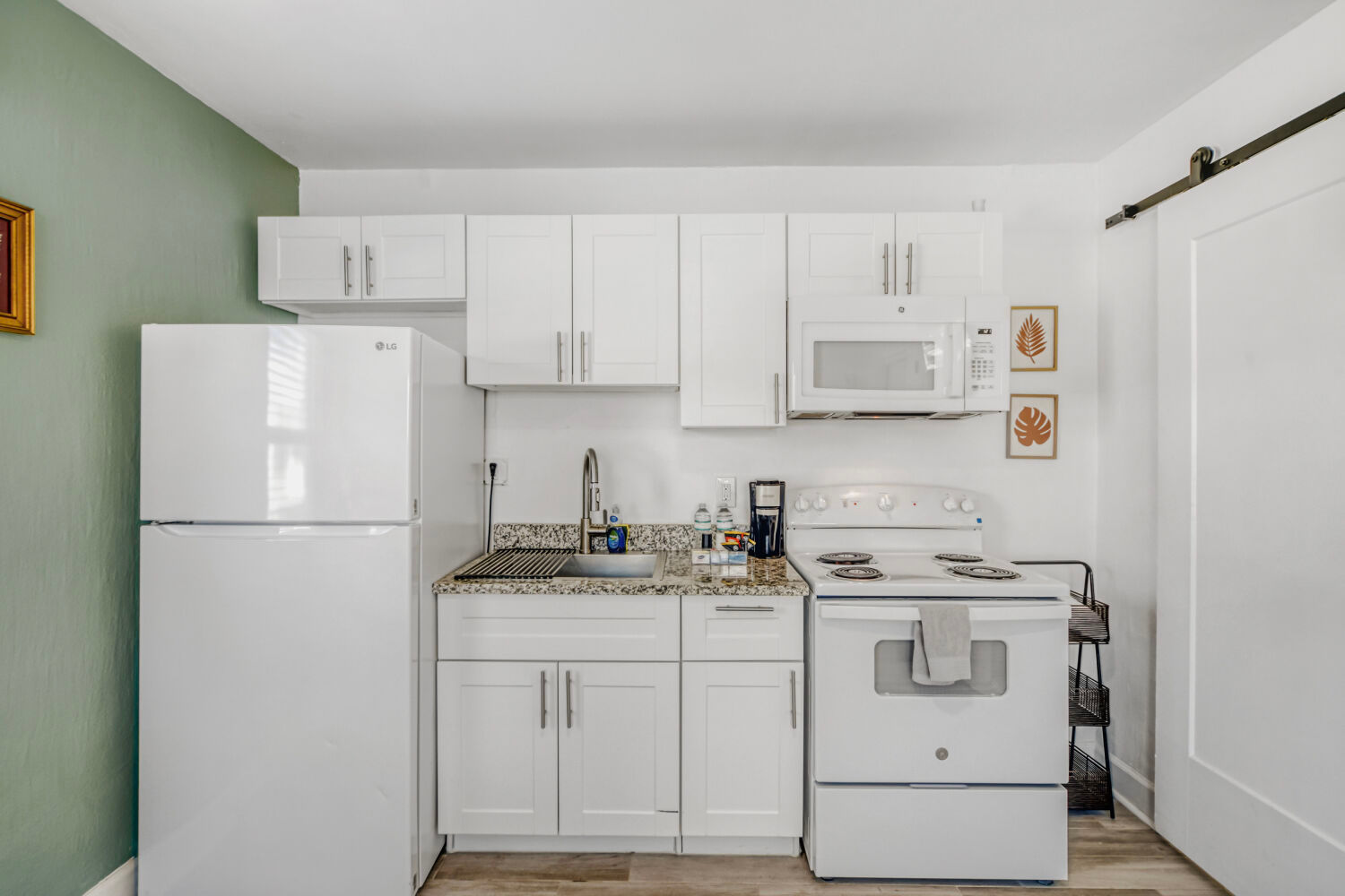 image  Kitchenette with a refrigerator, microwave, oven, and sink for simple meal preparation.