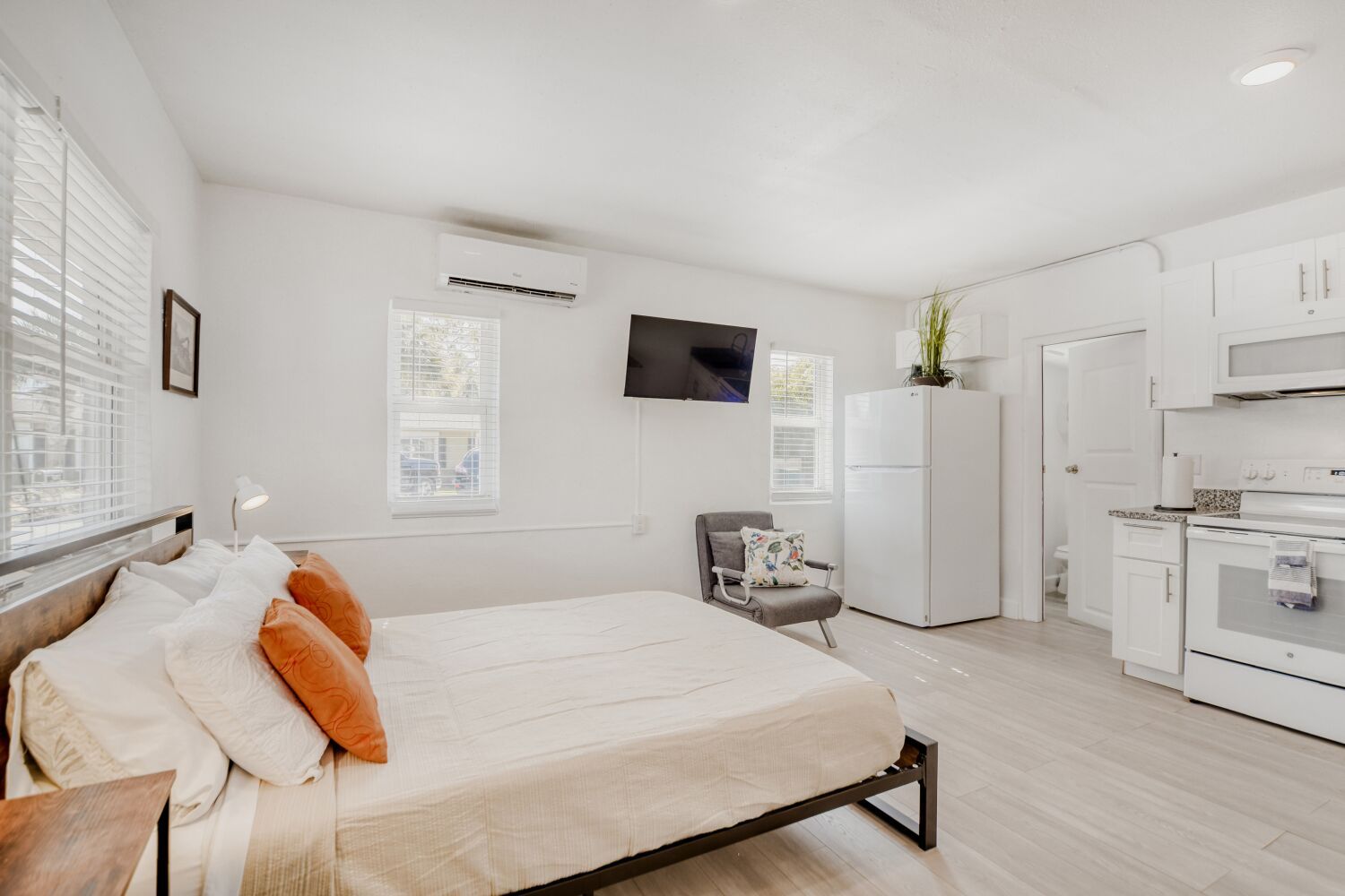 image Bright space combines a comfortable bed, kitchen, dining nook, and large windows for seamless living and restful nights.