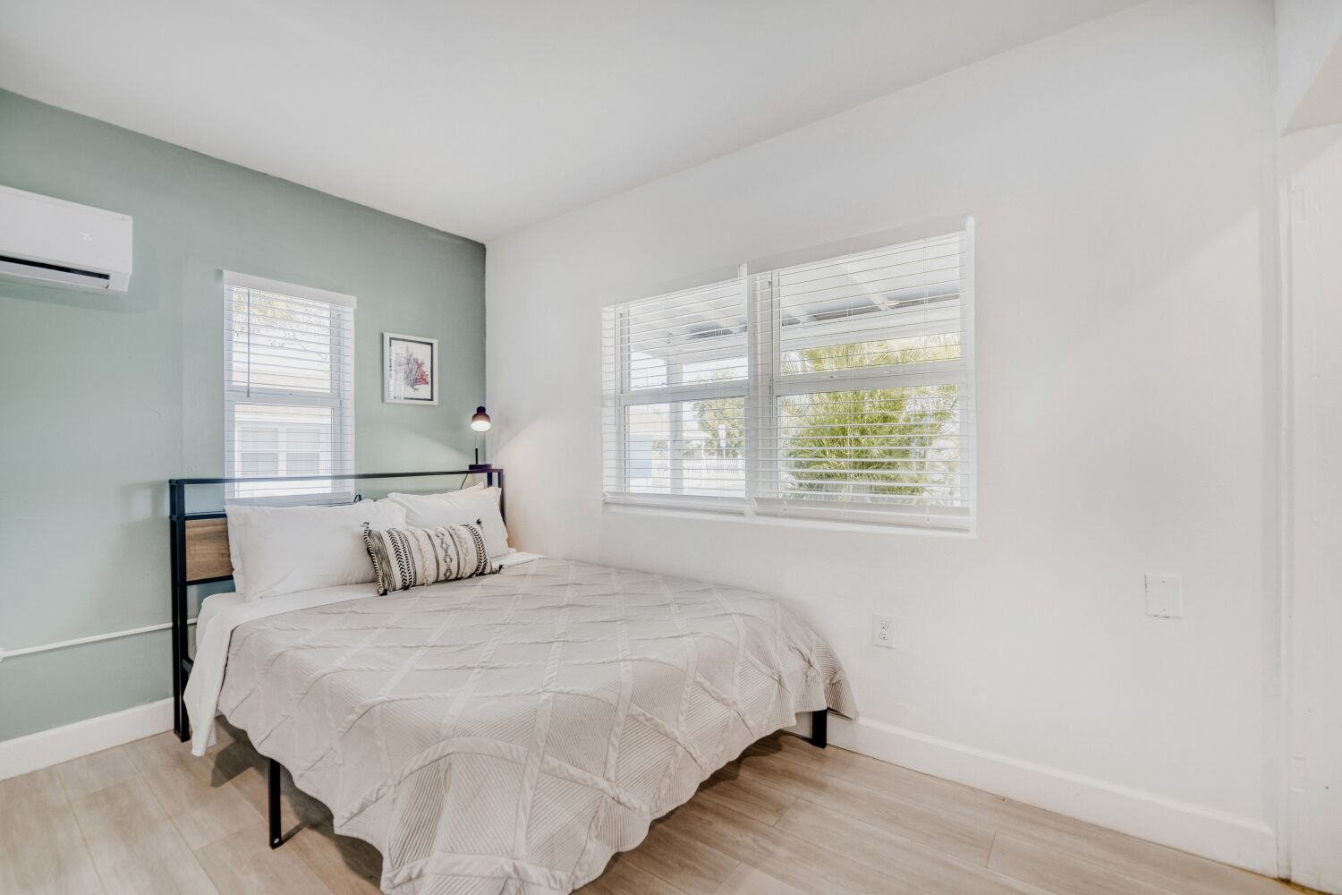 image Serene sleeping area invites you to unwind with a comfortable bed, crisp linens, and abundant natural light from large windows.