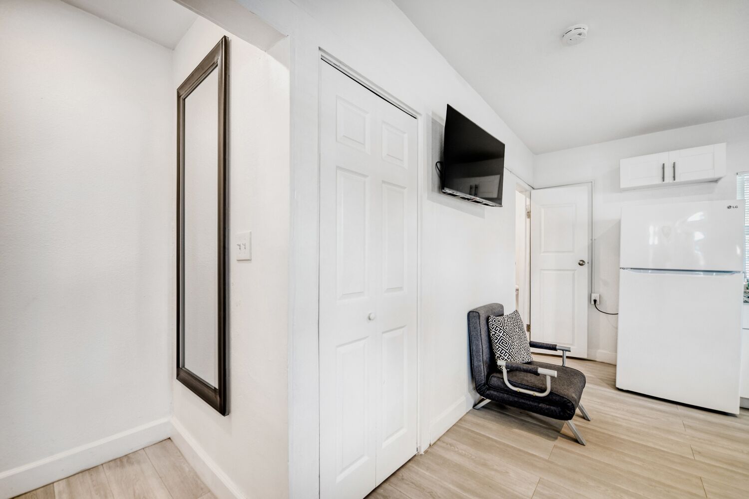 image Entryway includes a large mirror, flat-screen TV, and thoughtful seating, blending style and functionality for a seamless guest experience.