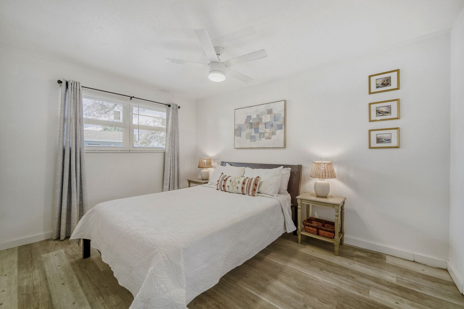 image Bright bedroom offers a cozy bed, charming bedside tables, reading lamps, and plenty of natural light for a tranquil retreat.