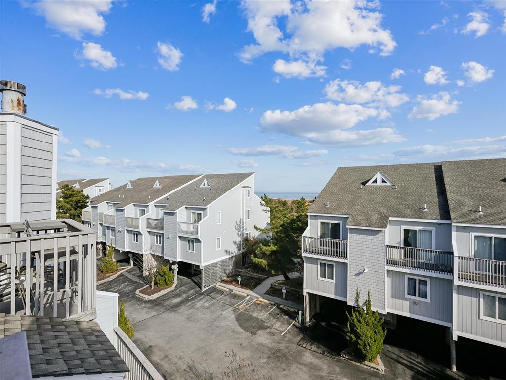 image Elevated view over neighboring townhomes and big blue skies highlights the home’s peaceful ocean-block setting.