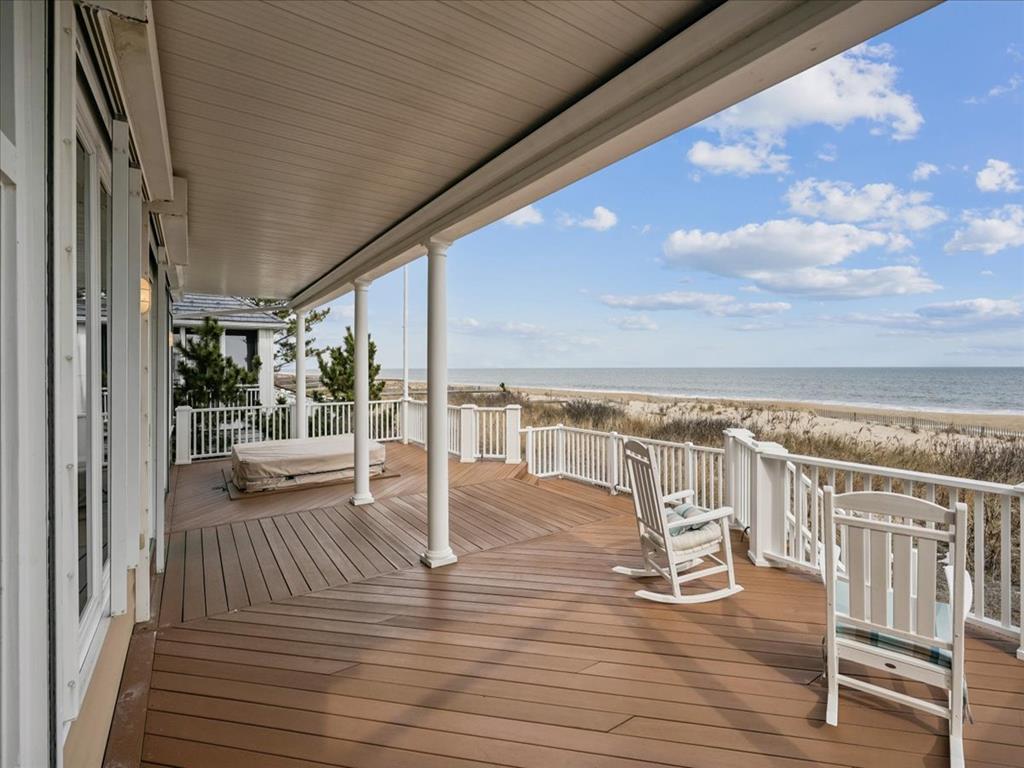 image The inviting deck area features comfortable seating, hot tub, and seamless access to the serene beach just steps away.