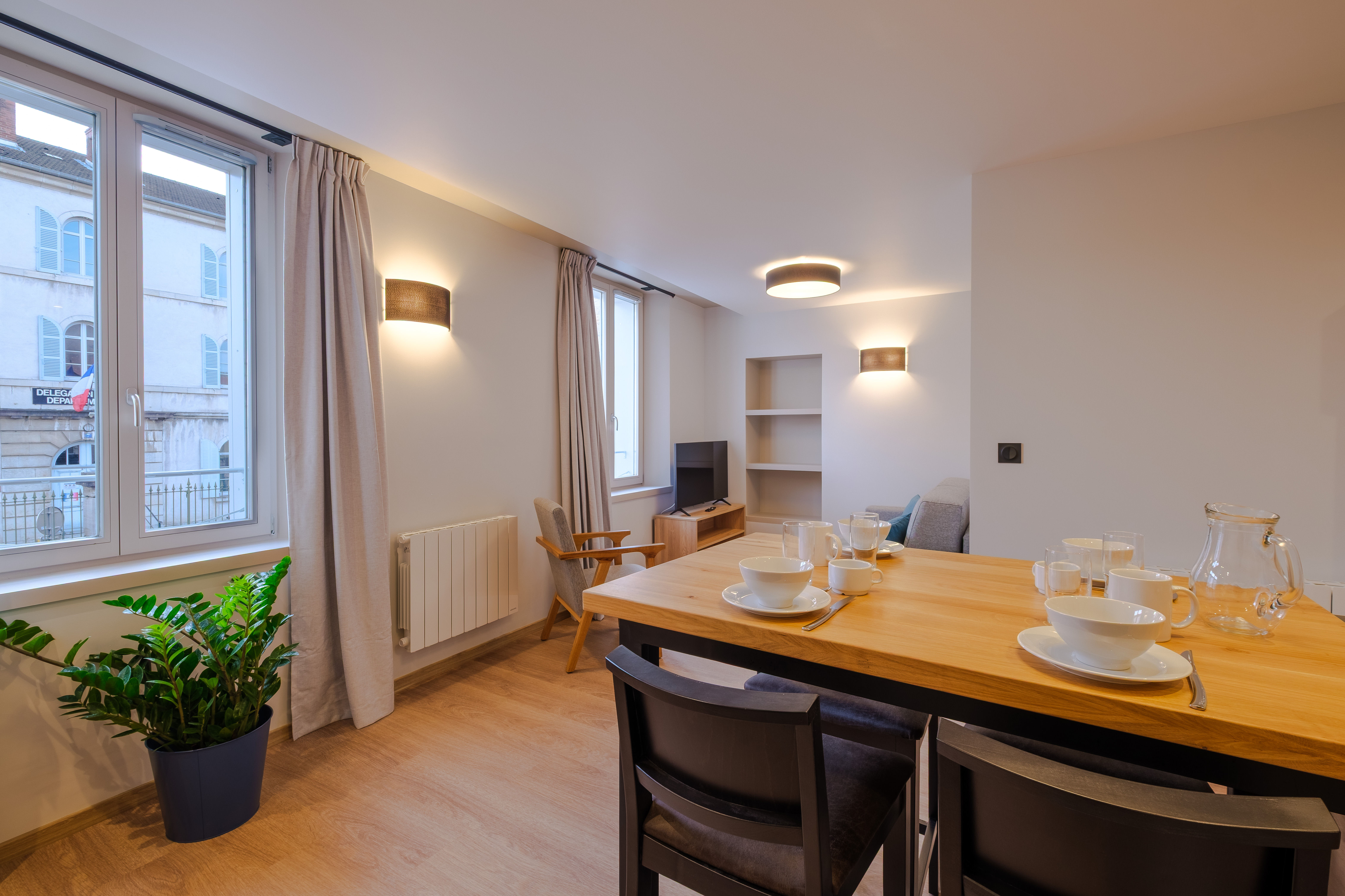 image An inviting dining space is set with tableware and bathed in natural light, creating a warm and welcoming atmosphere for meals.